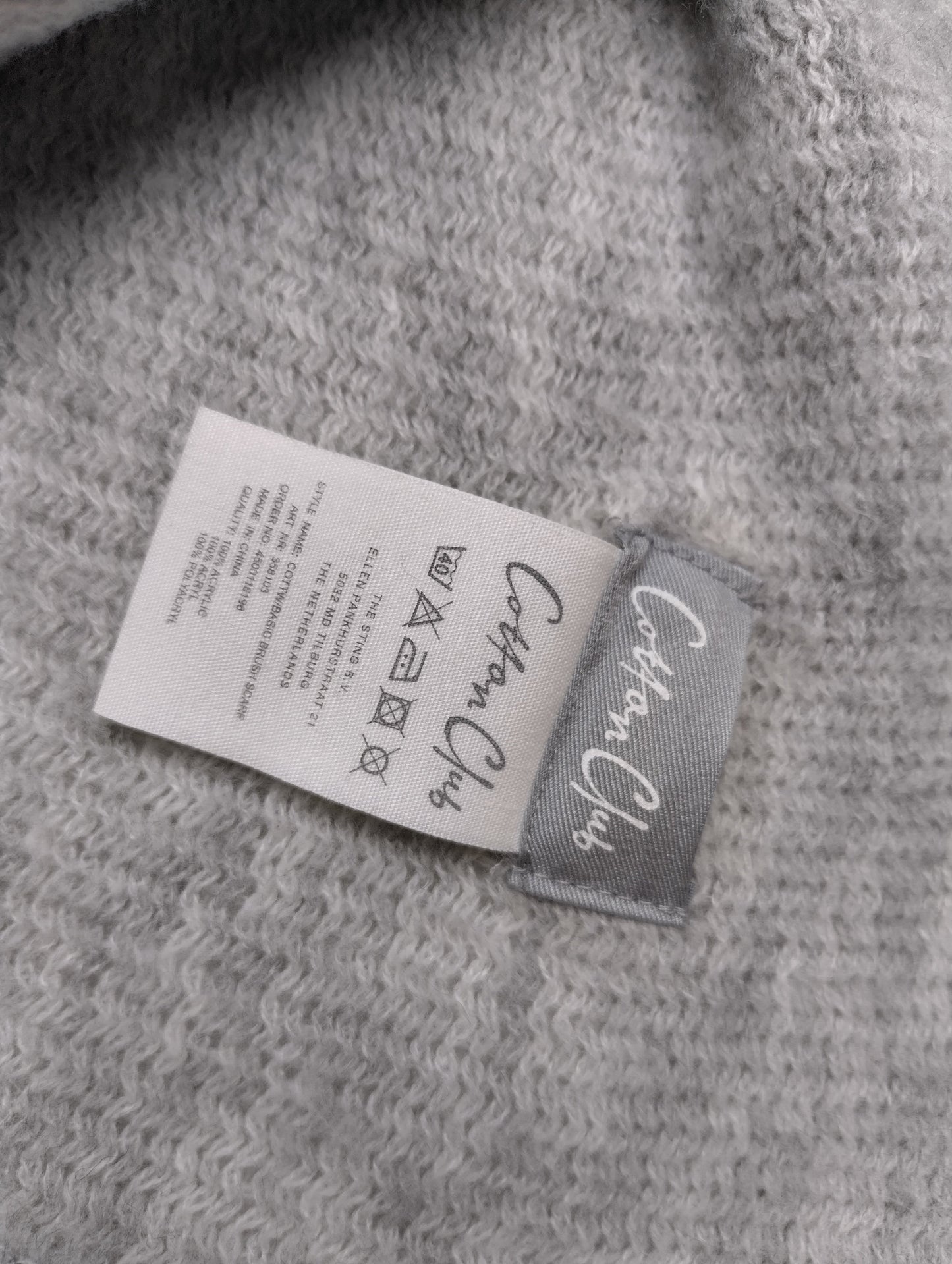 Close-up of the scarf's label and care instructions