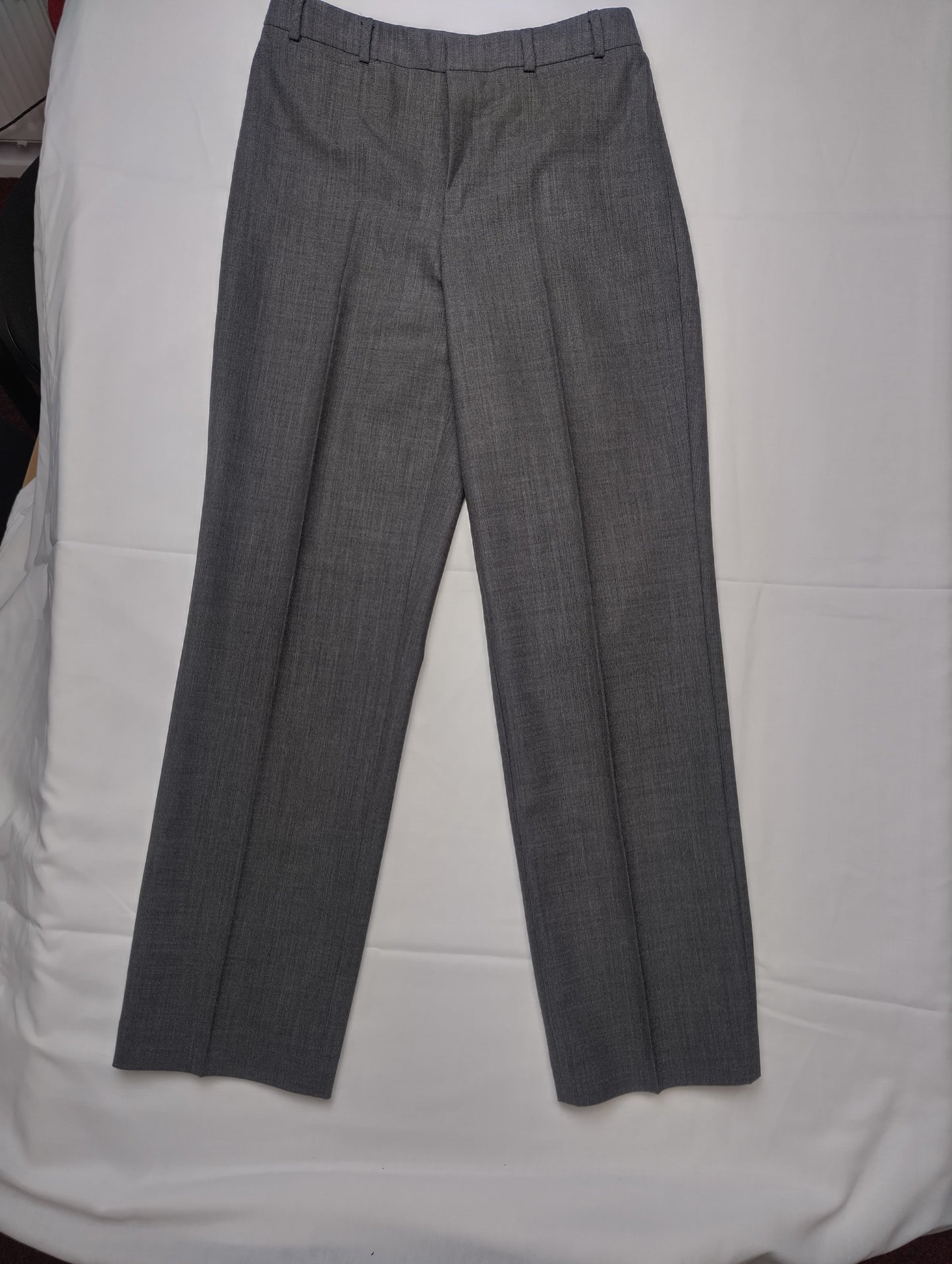 Full view of grey dress pants on a white background