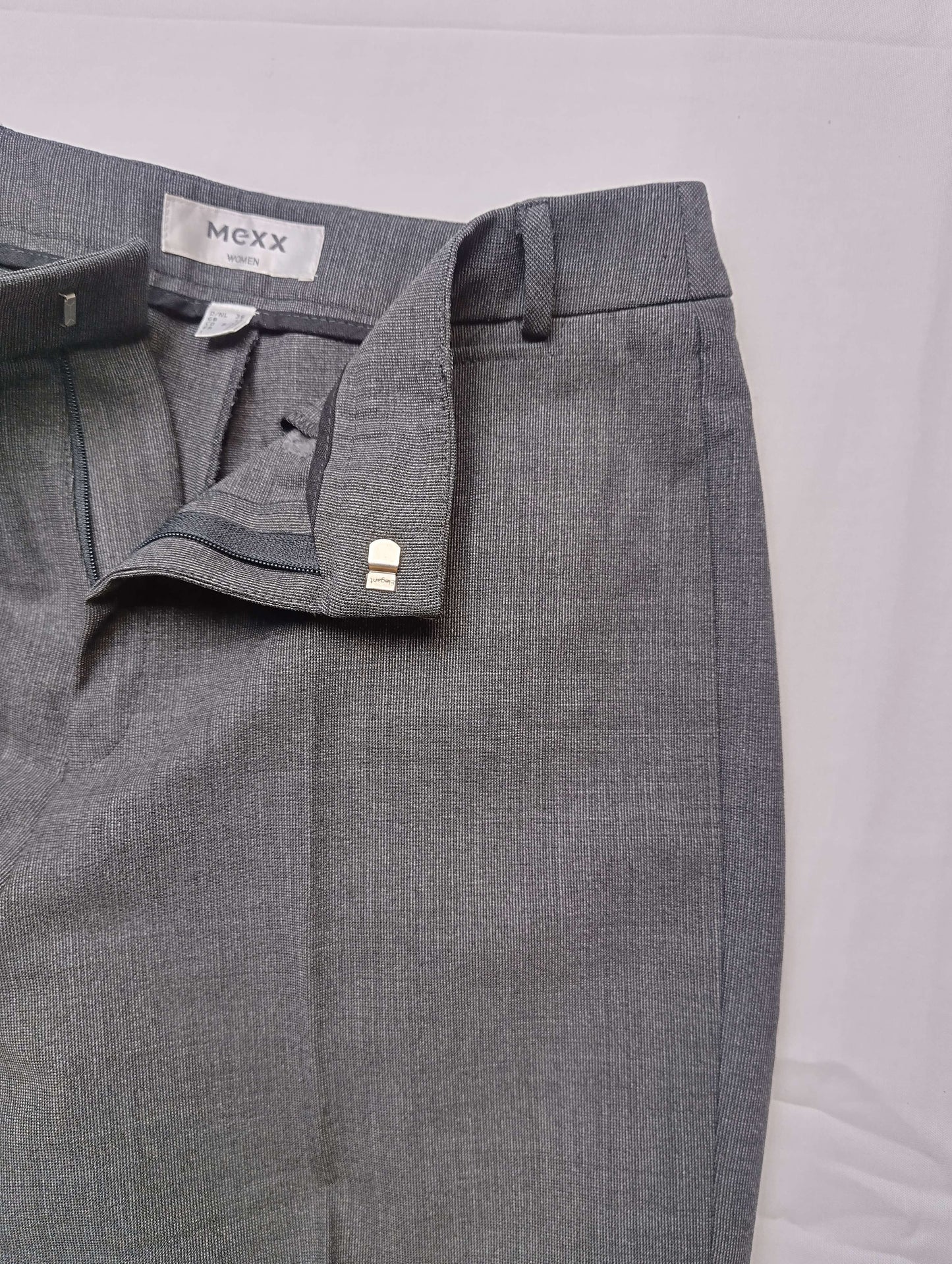 Detail view of waistband and closure of grey dress pants