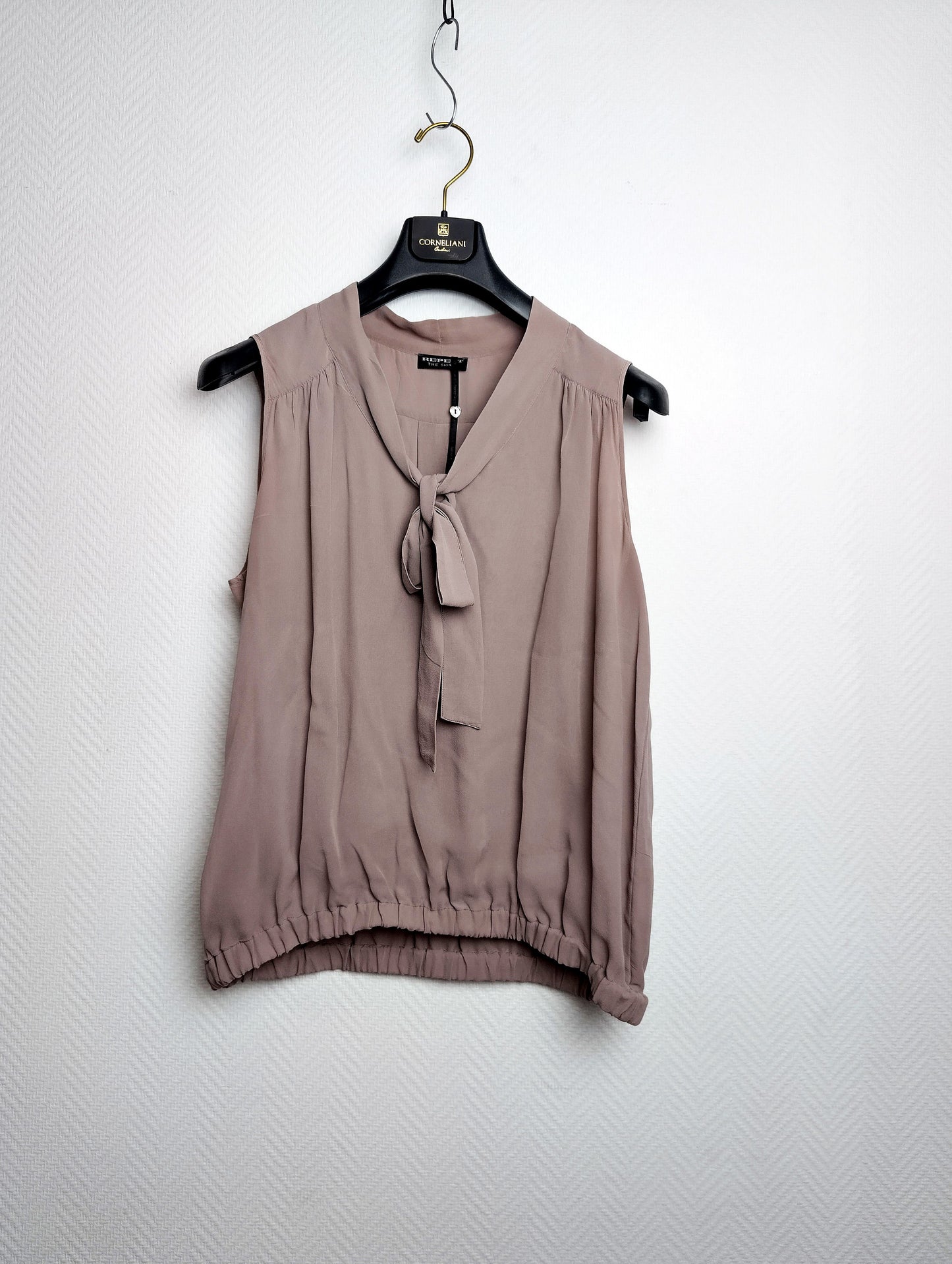 Front view of silk blouse on hanger