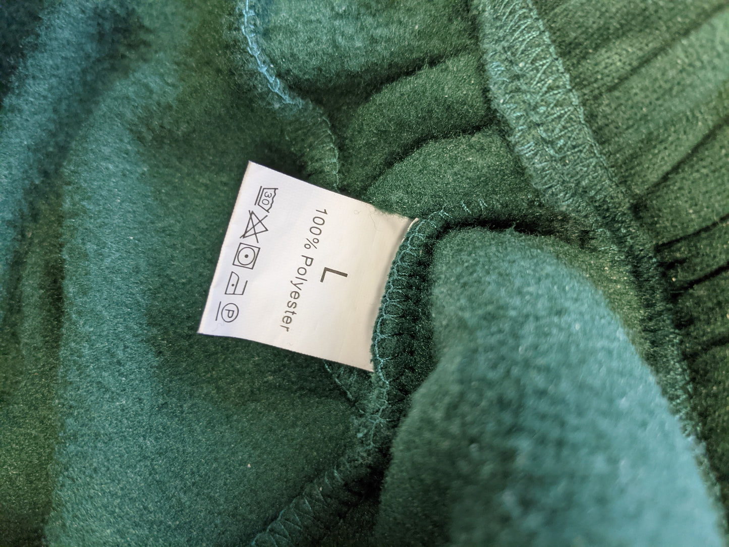 Label of green hoodie showing size and material