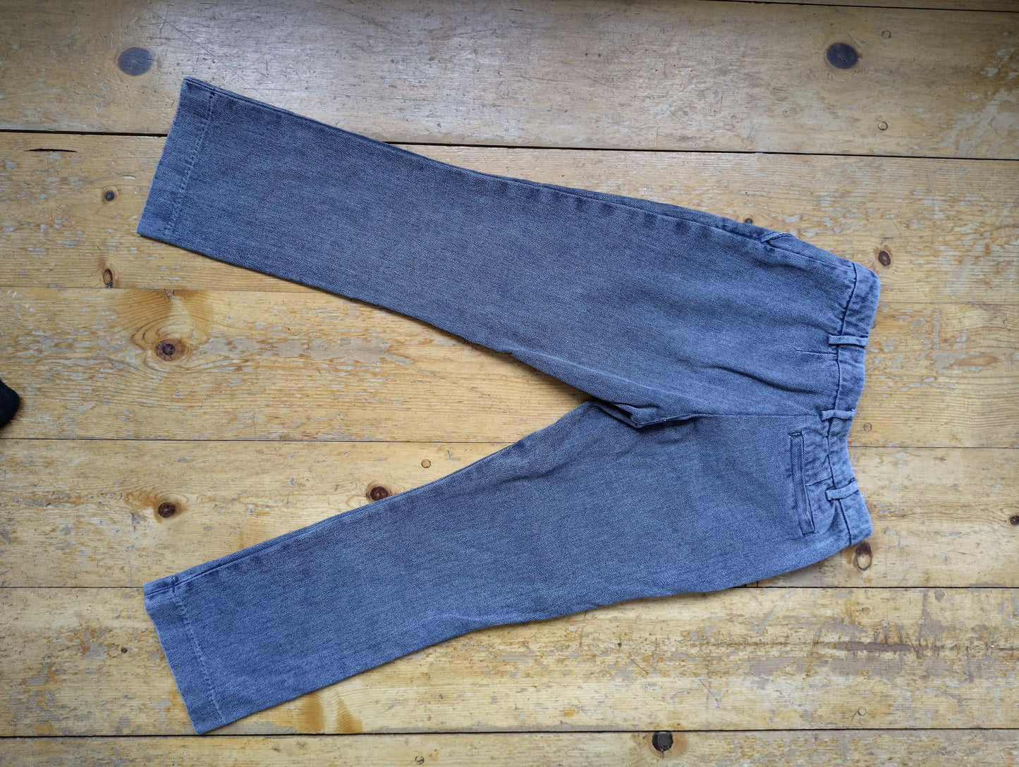Back view of blue trousers on a wooden floor