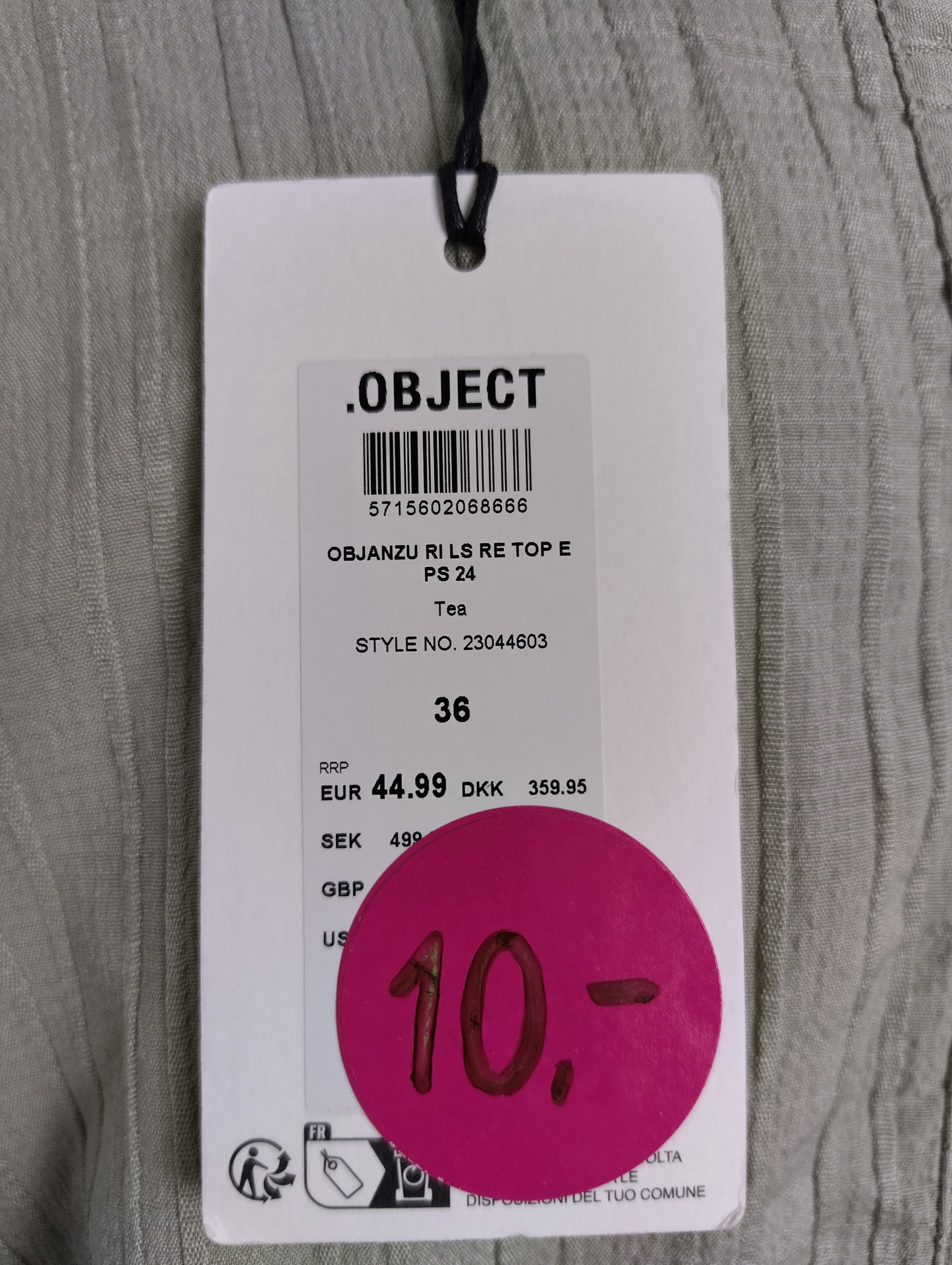 Close-up of Object brand tag on green blouse