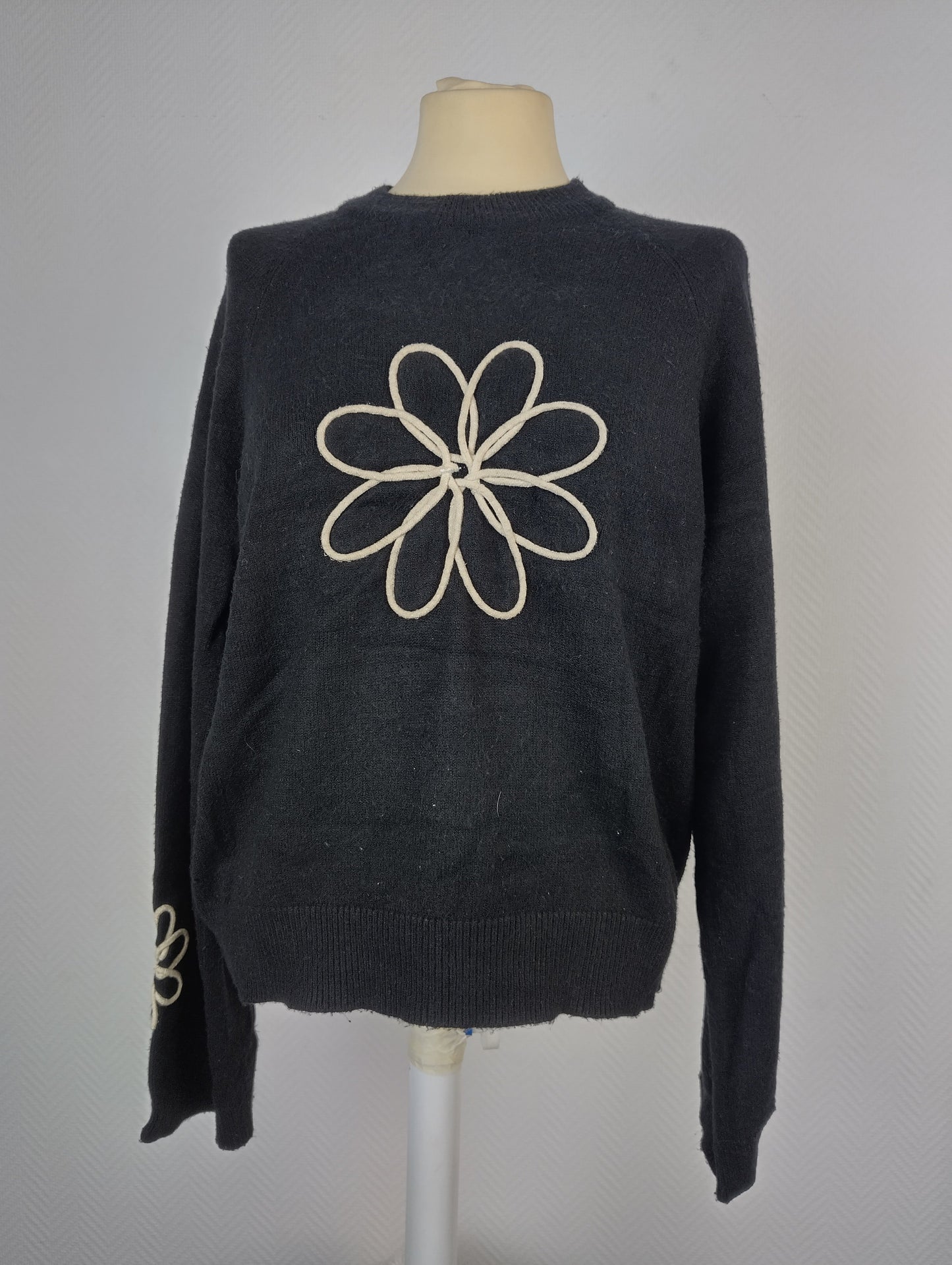Front view of black sweater with floral design