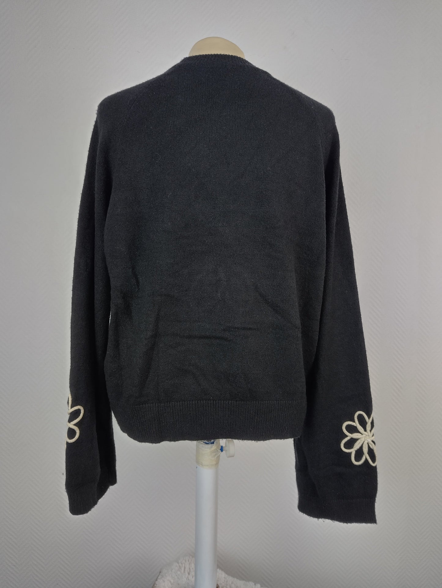 Back view of black sweater with floral design