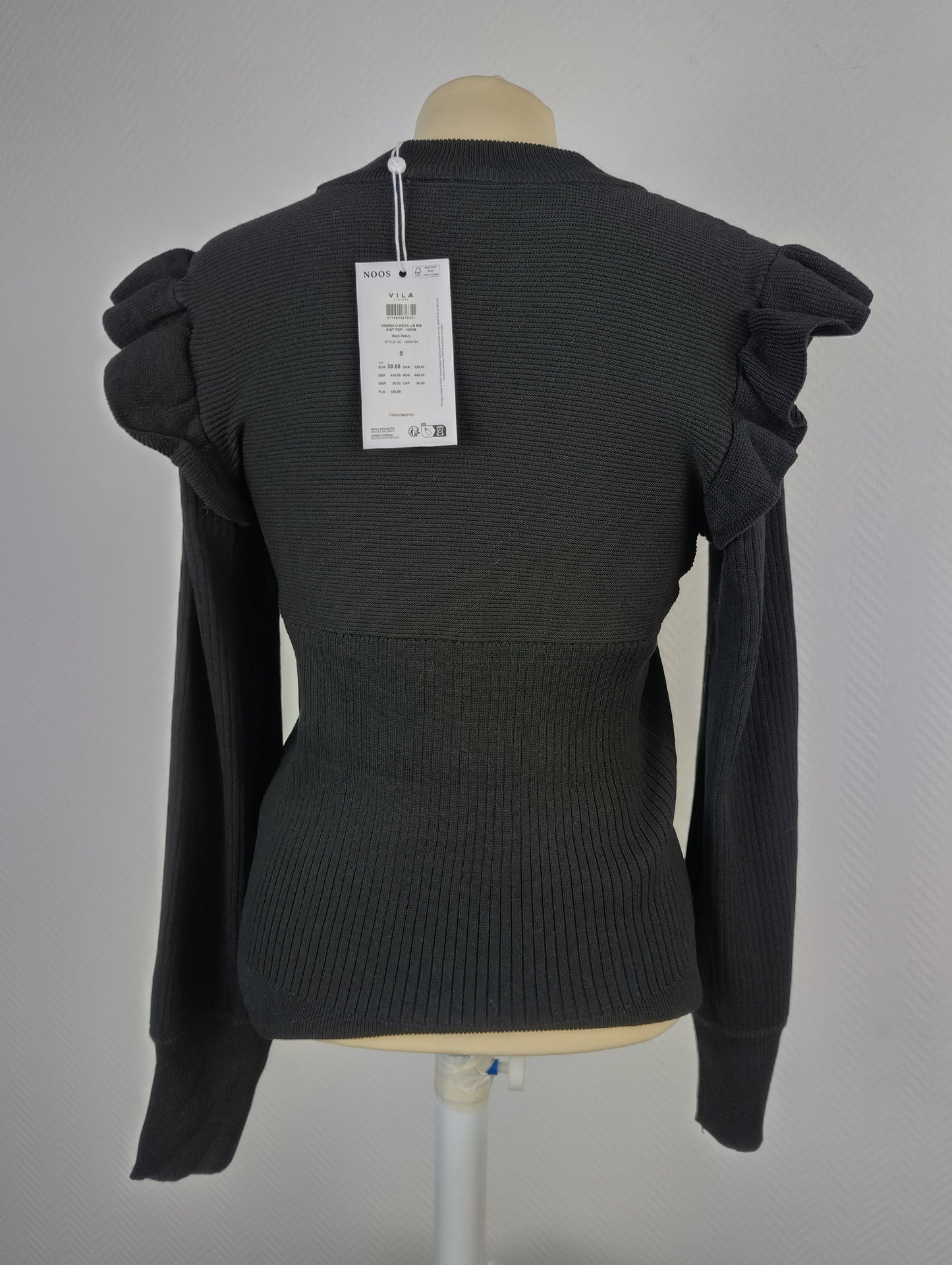 Back view of black ribbed knit top with ruffle shoulders