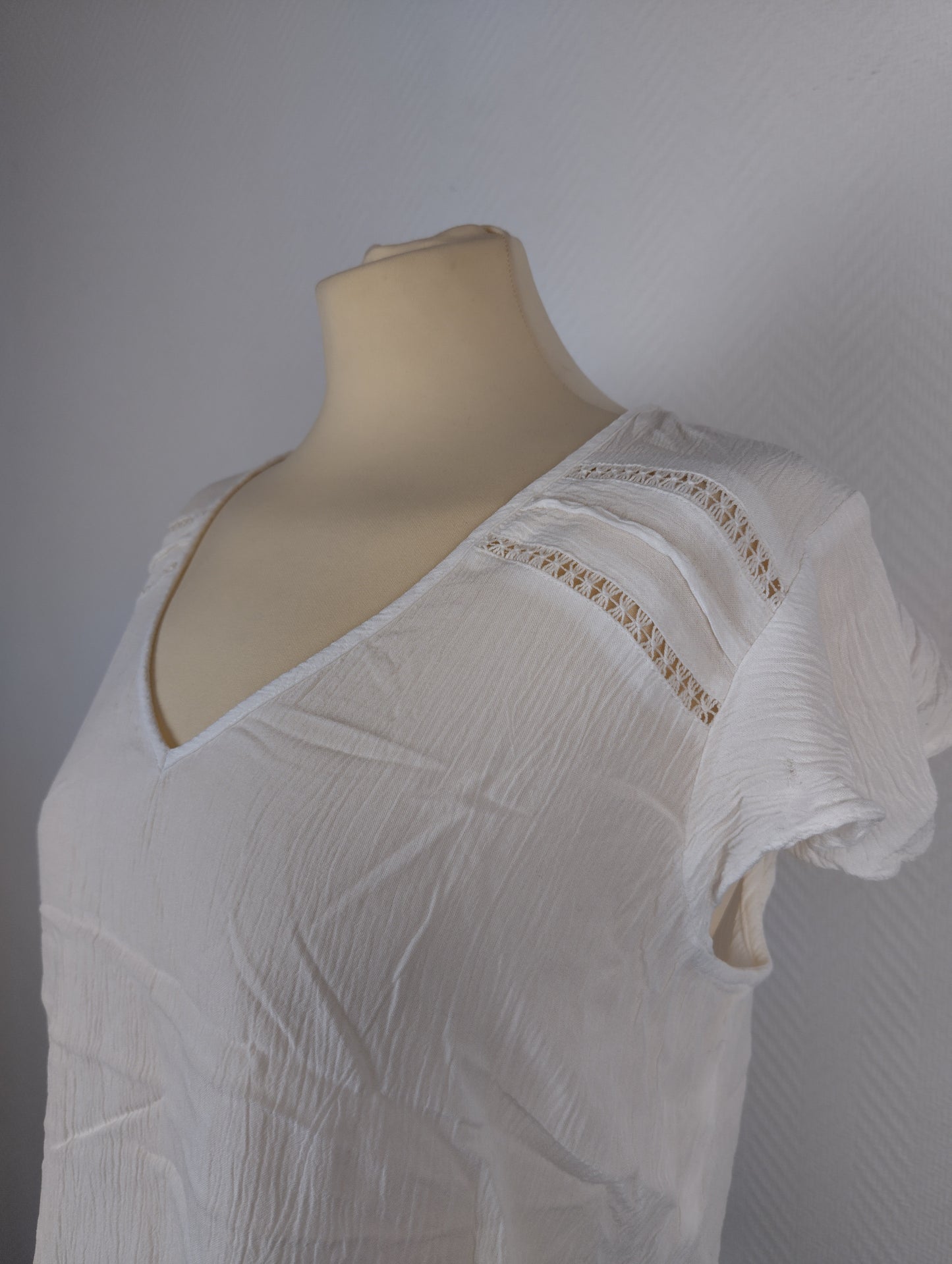 Close-up of white textured blouse with lace detail