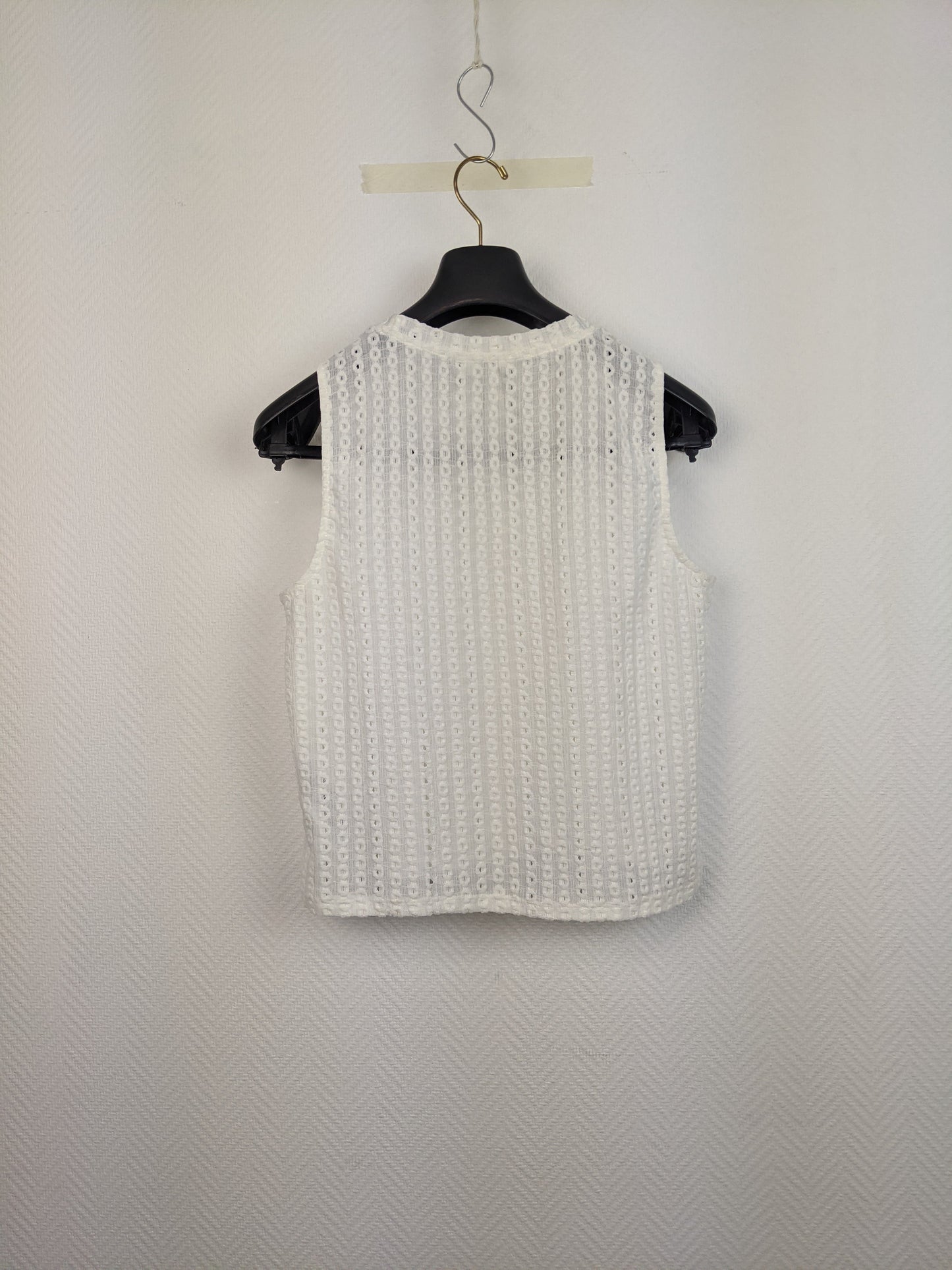 Back view of white eyelet sleeveless top on hanger