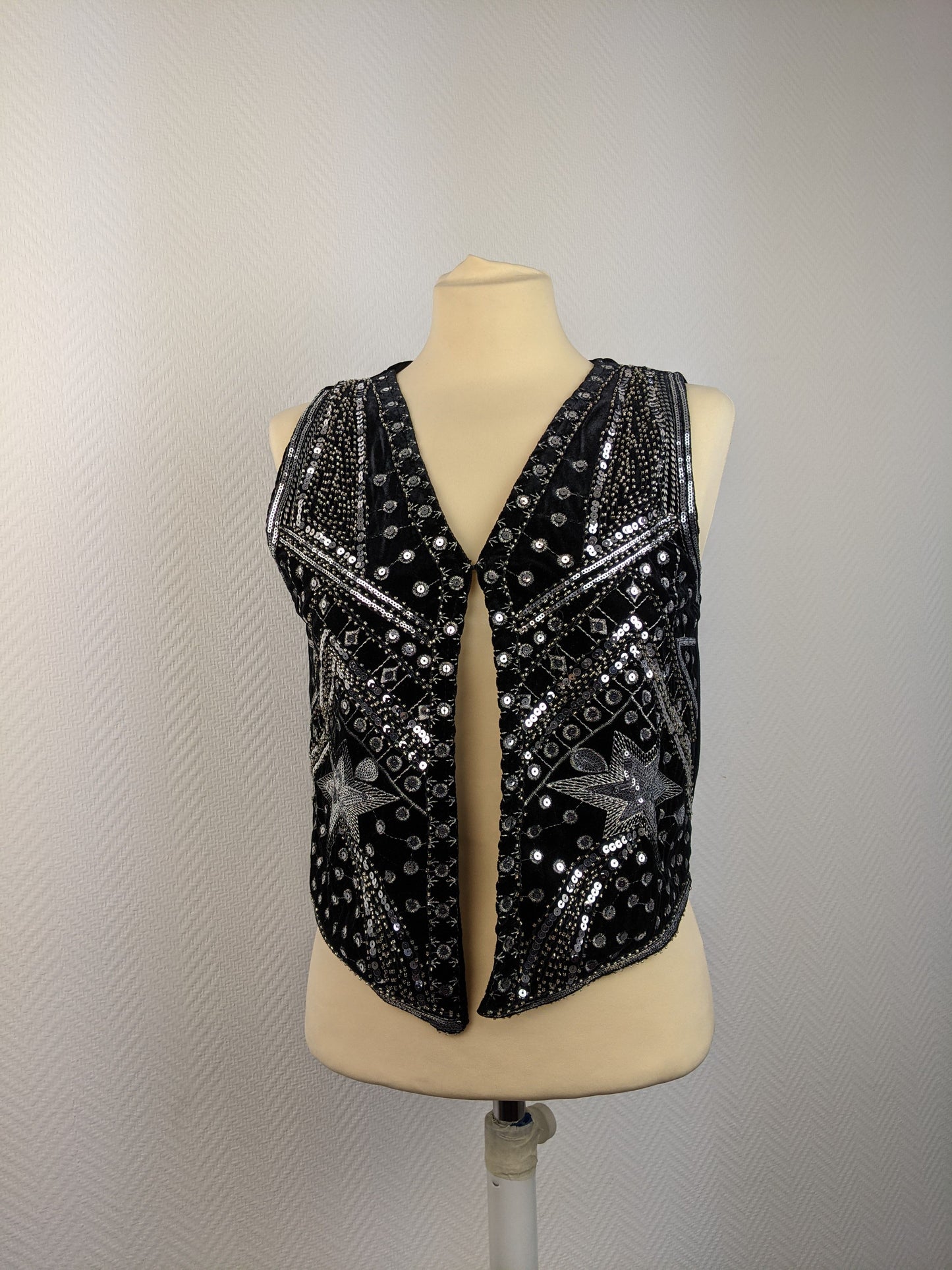 Front view of black sequined vest on mannequin