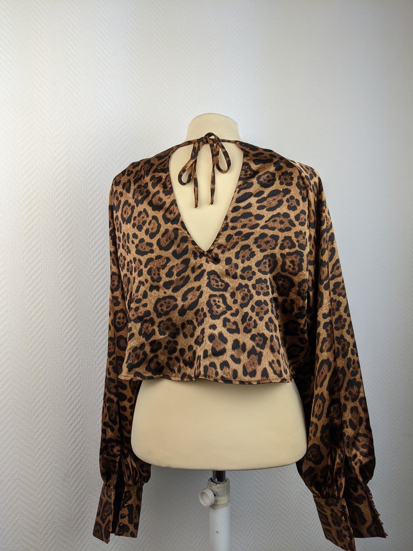 Back view of leopard print satin blouse with open tie detail
