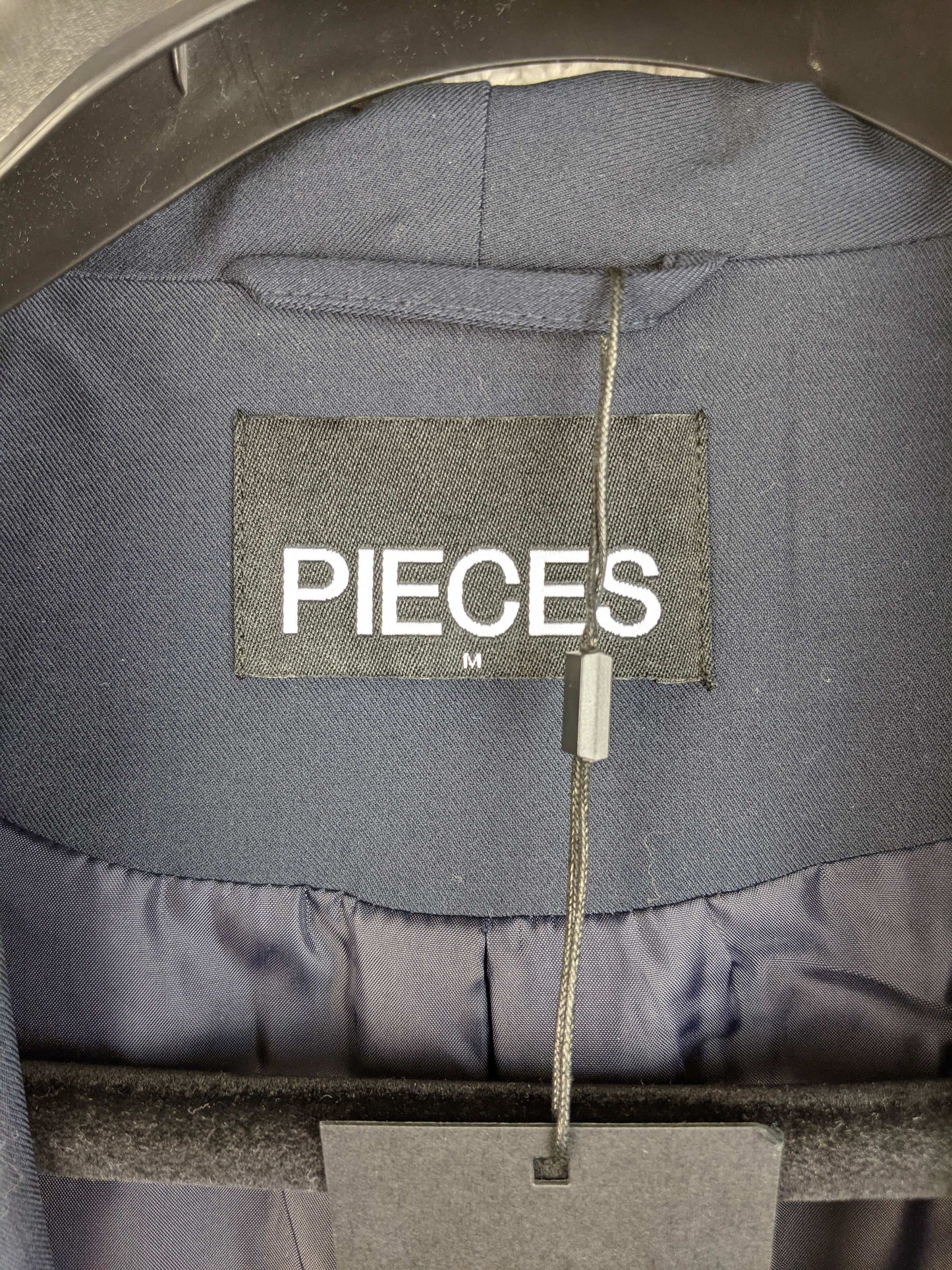 Close-up of Pieces brand label inside blazer