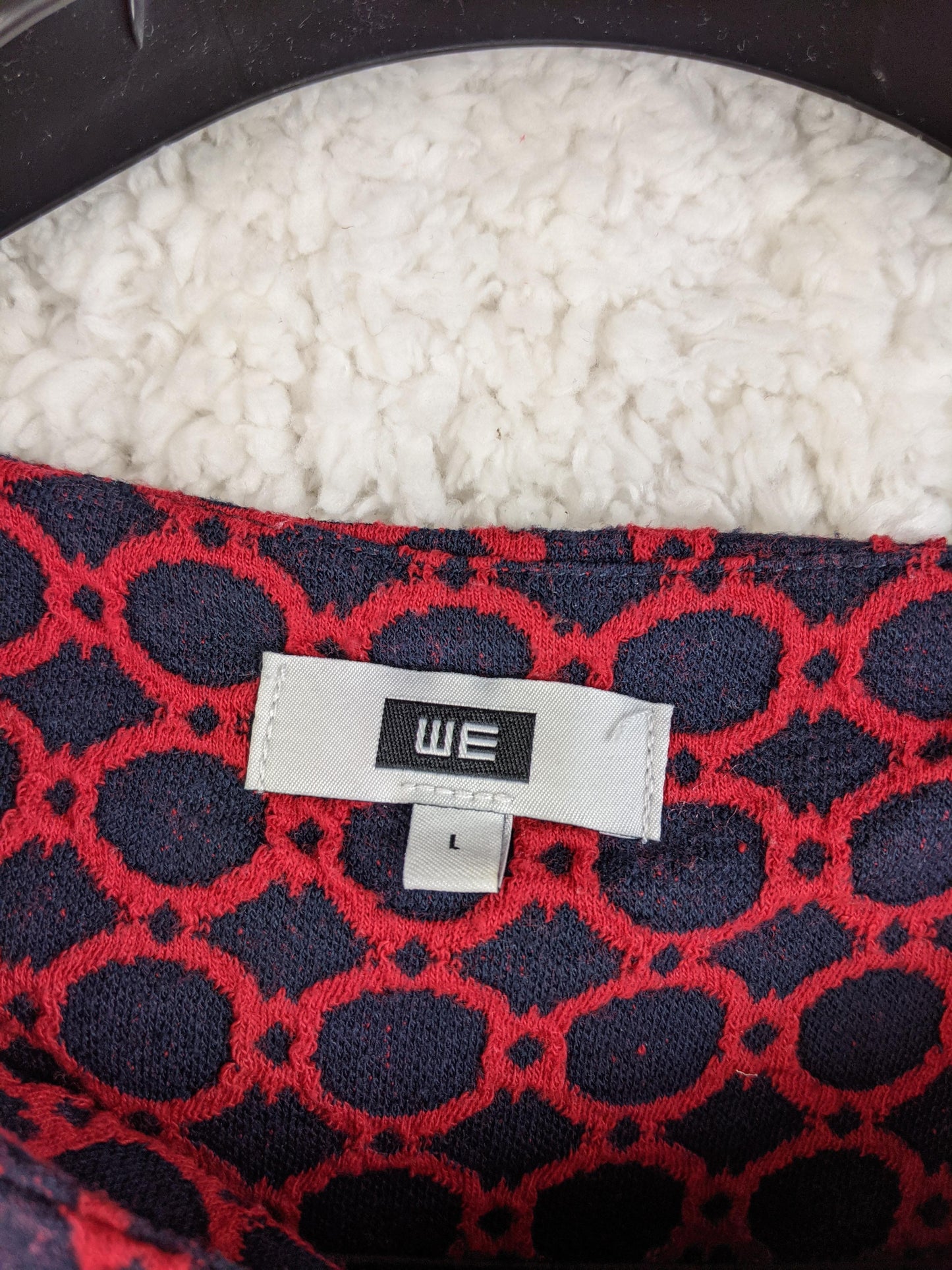 Close-up view of WE label on the dress