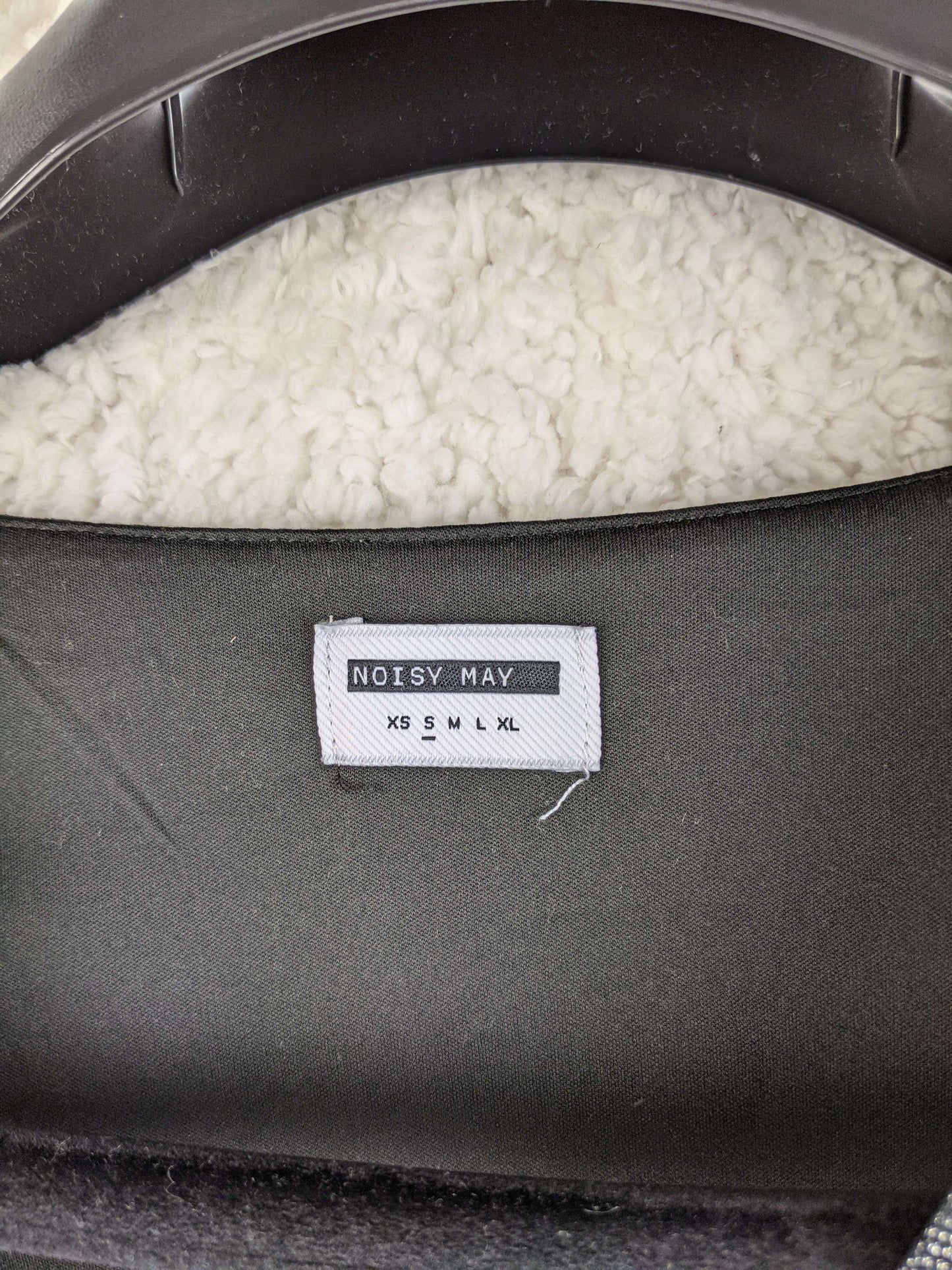 Close-up of Noisy May label showing size options
