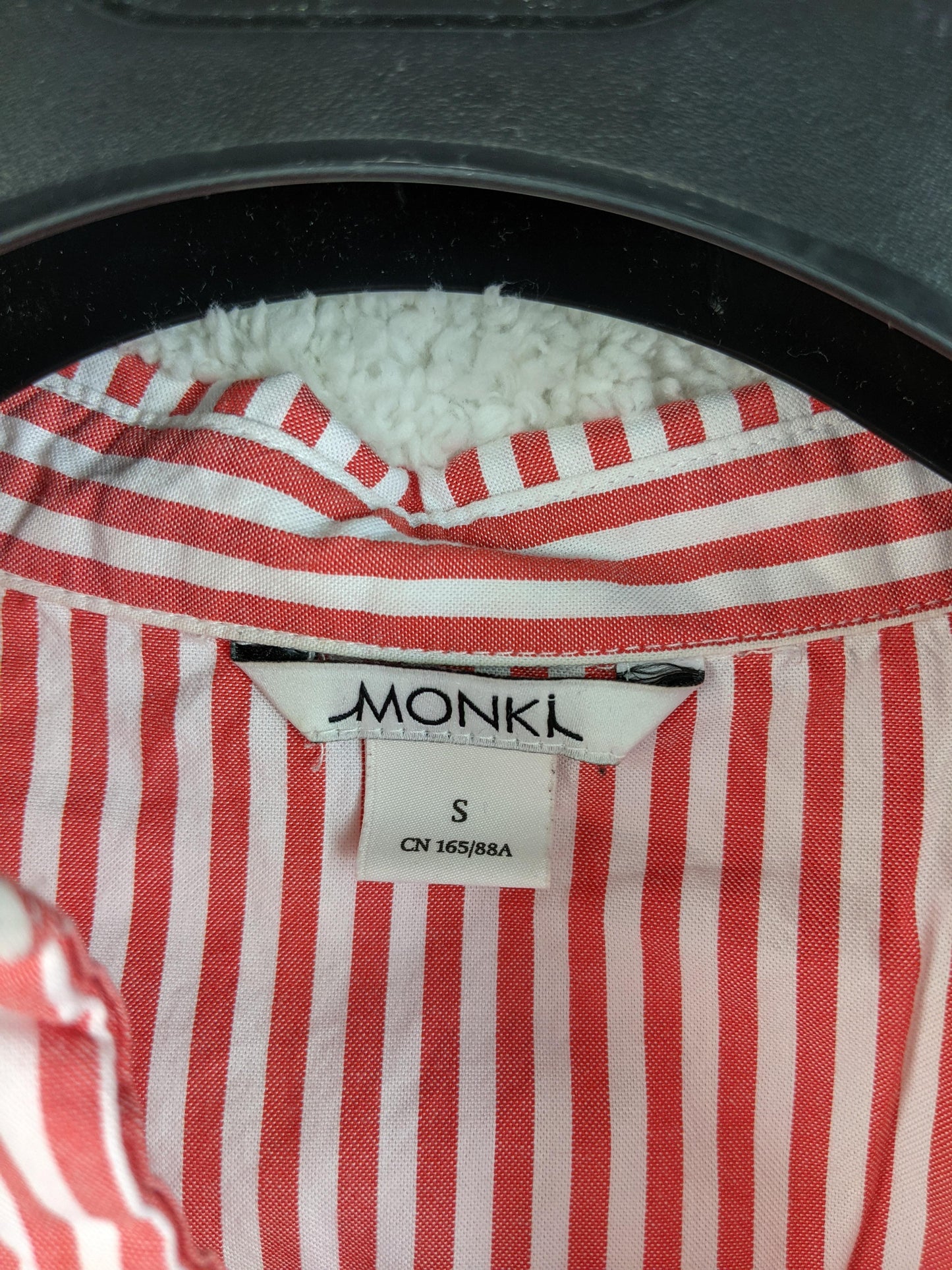 Close-up of Monki label on red striped shirt