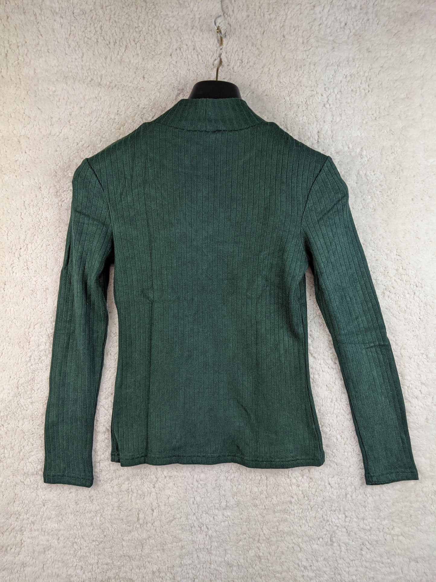 Back view of green ribbed long sleeve top on hanger