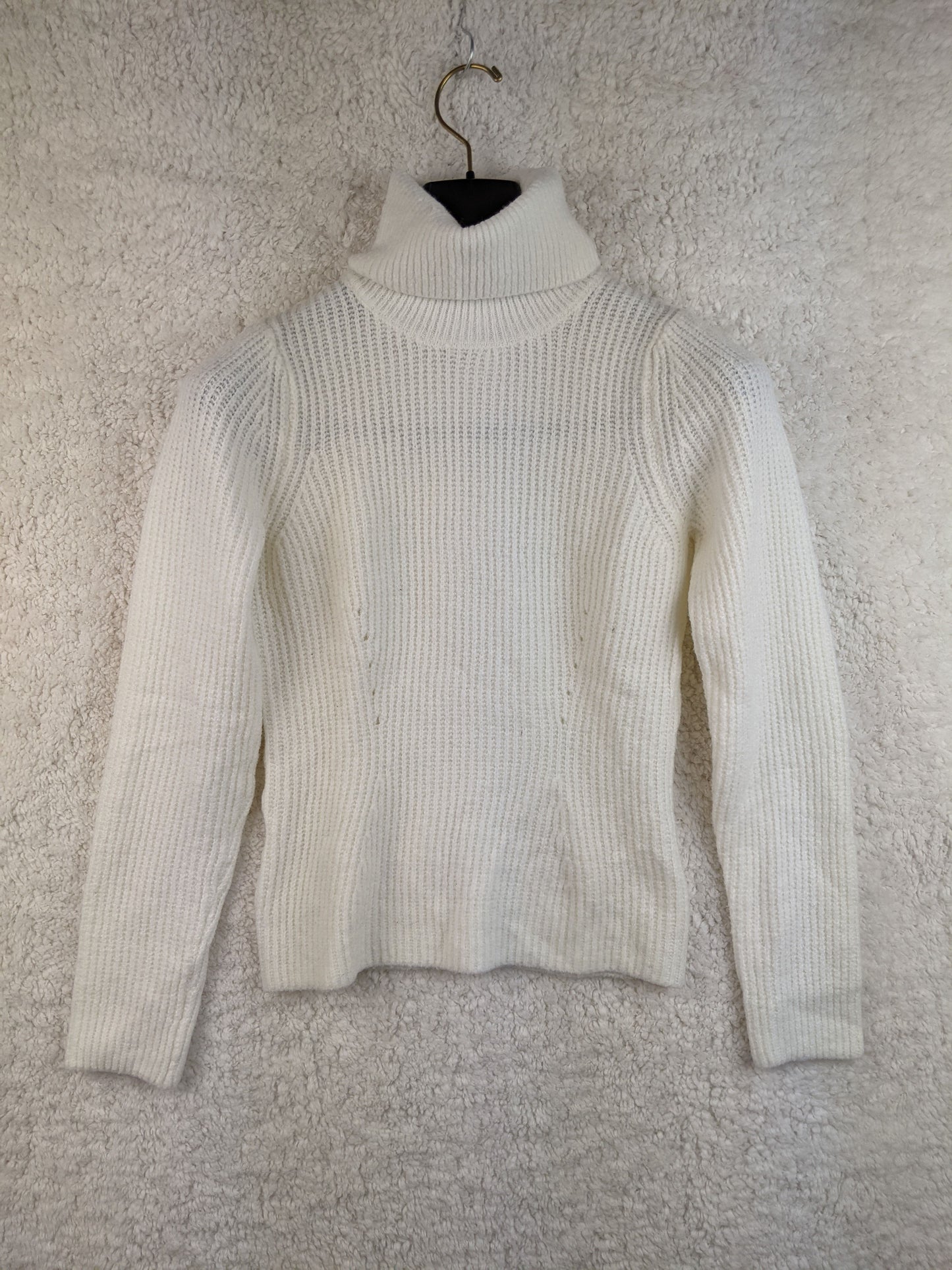 Front view of white ribbed turtleneck sweater