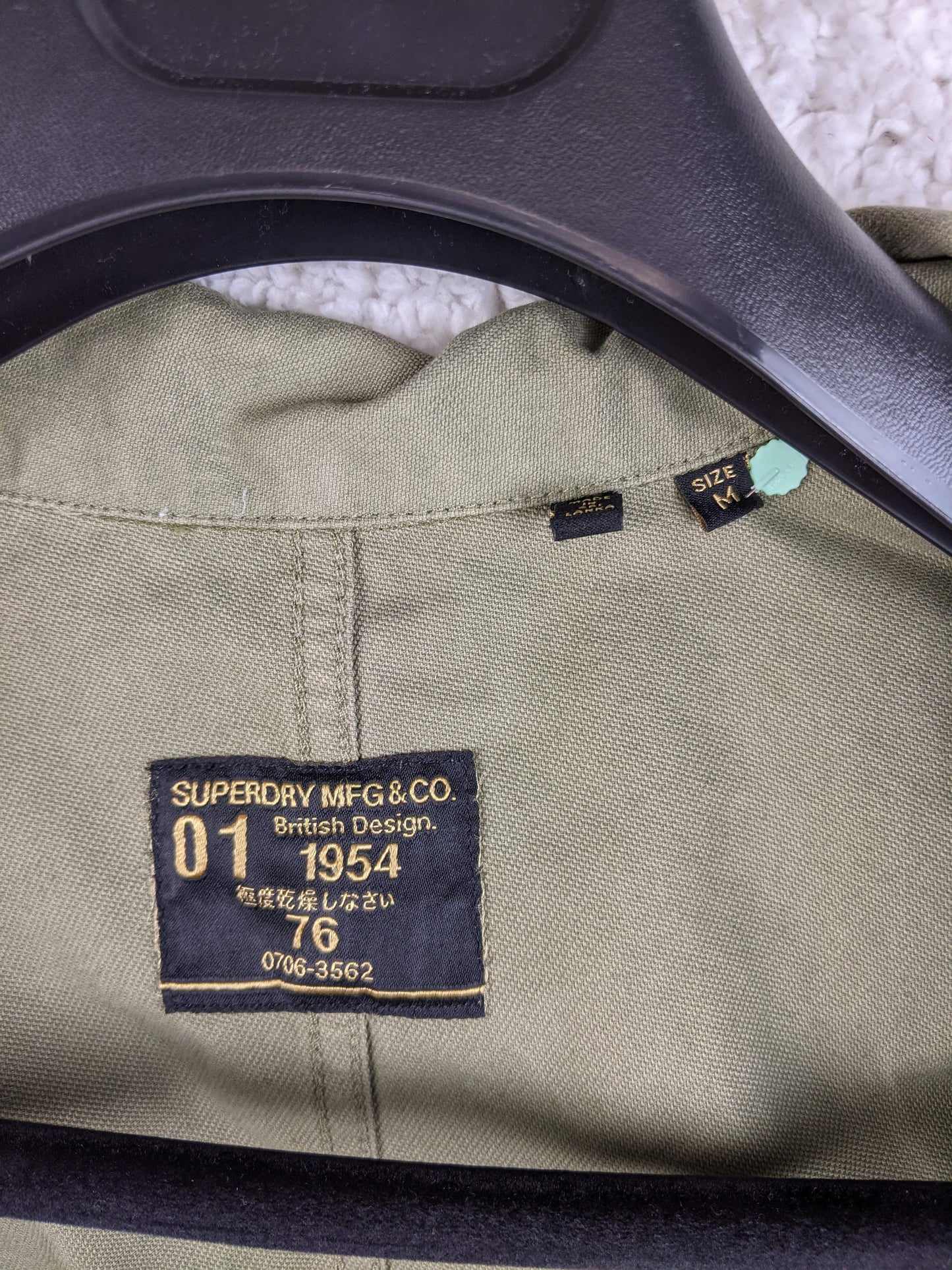 Label of Superdry olive green workwear jacket showing brand details