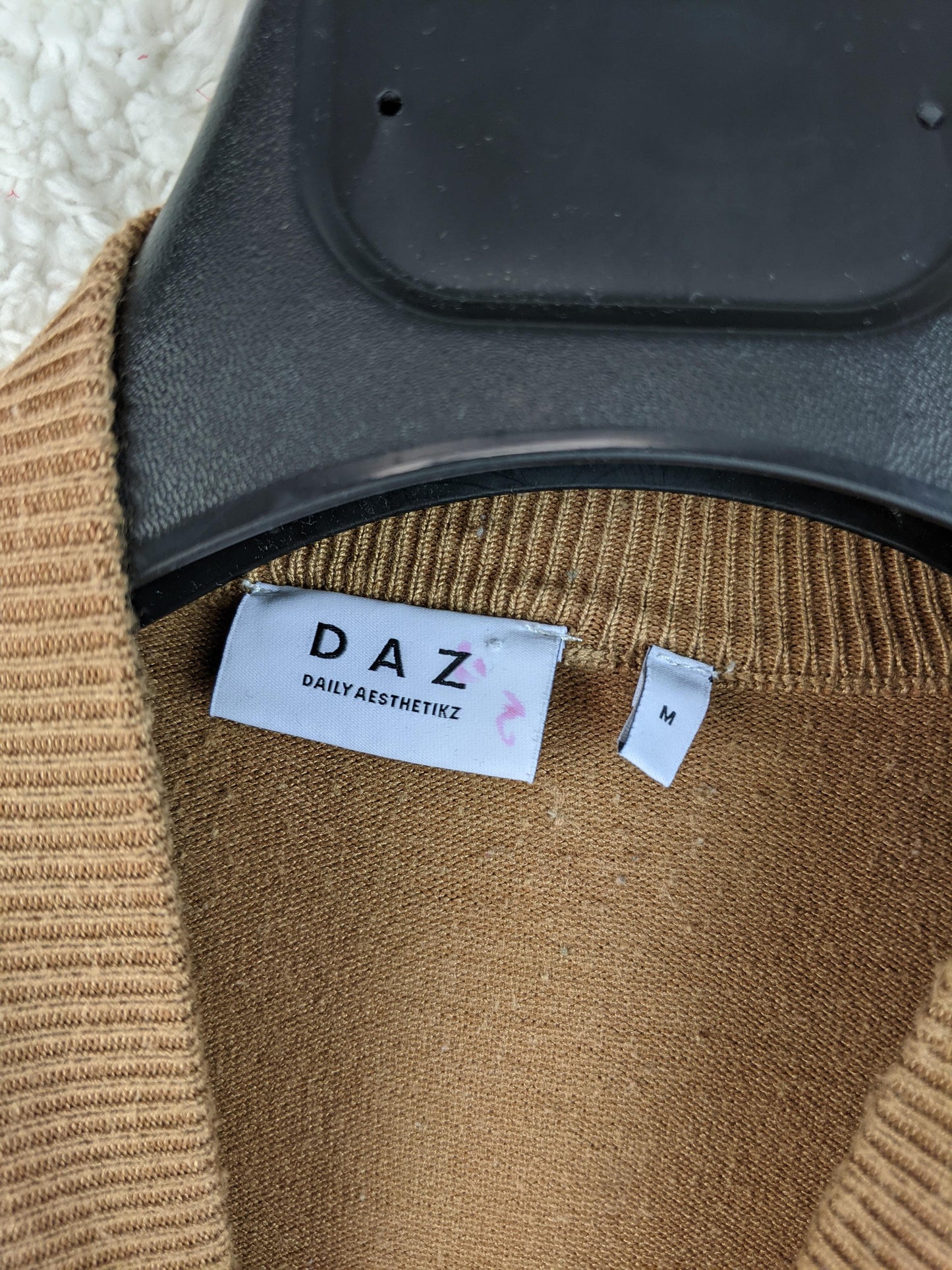 Close-up of DAZ sweater label showing size M