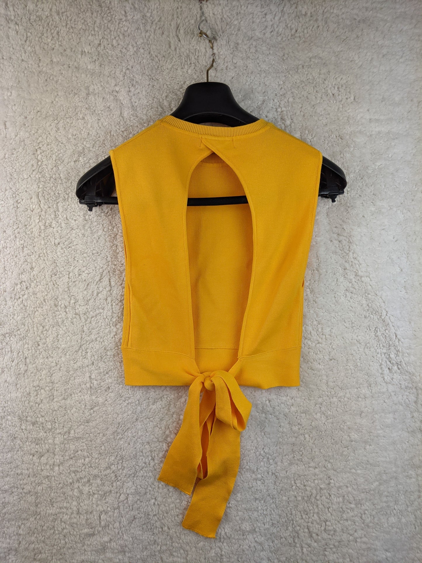 Yellow sleeveless top with tie-back on hanger - back view