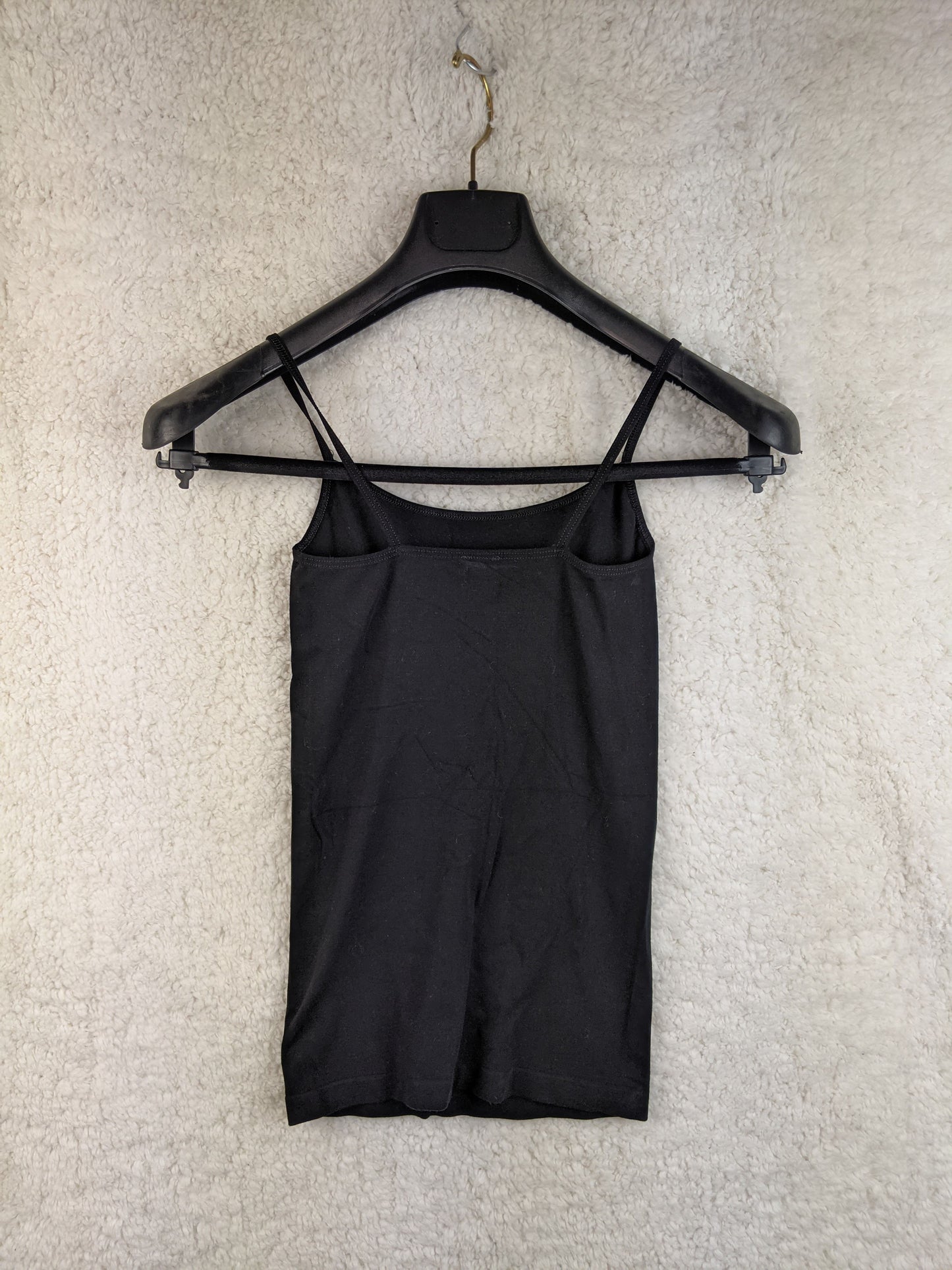 Back view of black spaghetti strap top on hanger