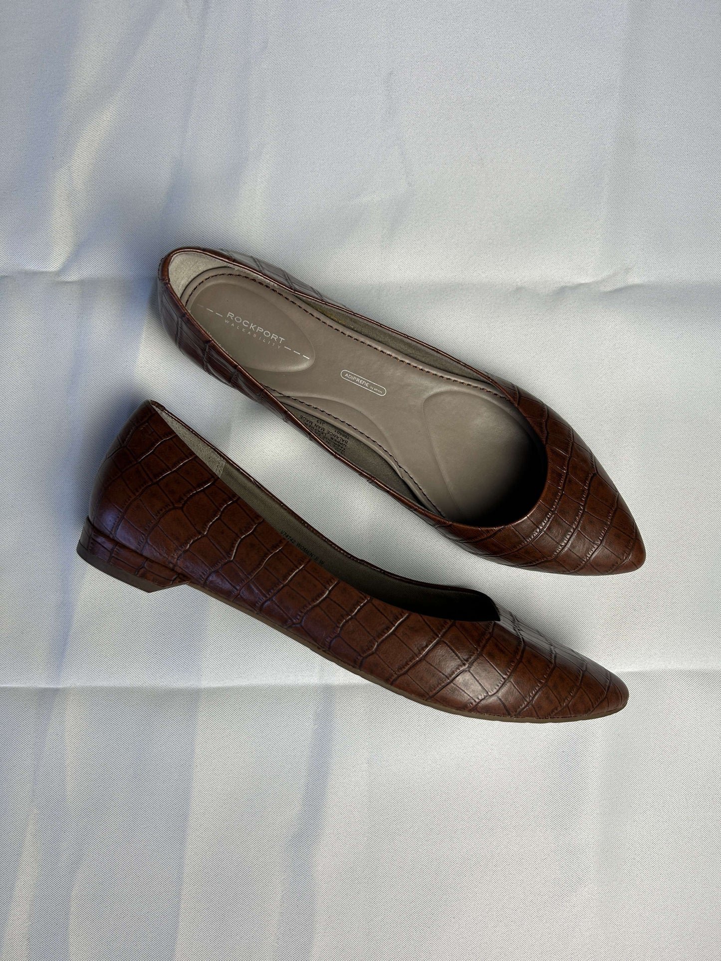 Side view of Rockport brown croc-embossed leather flats