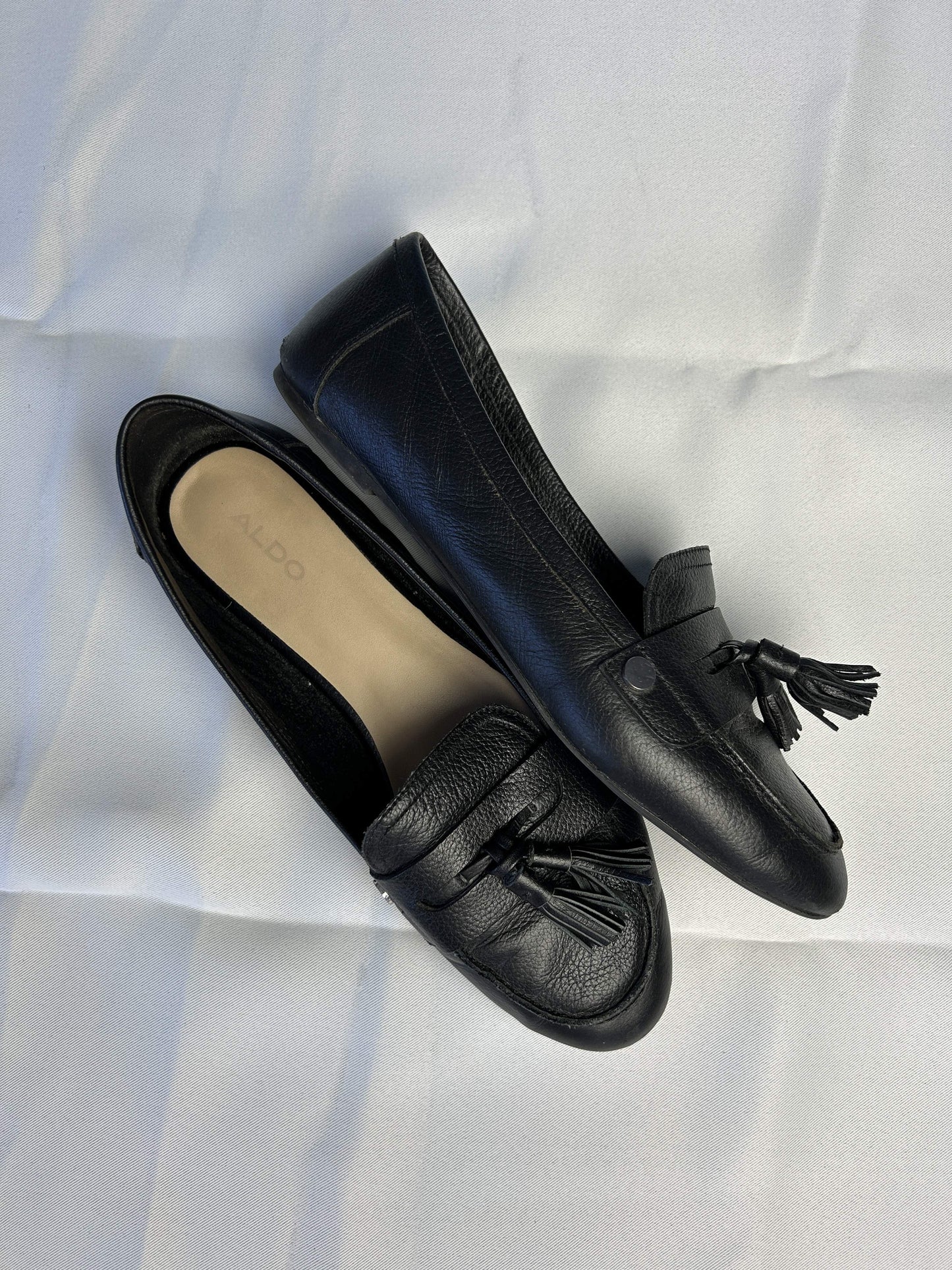 Side view of black Aldo loafers with tassels