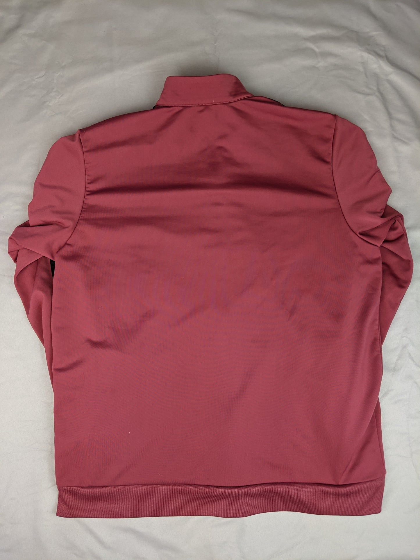 Back view of maroon Adidas track jacket