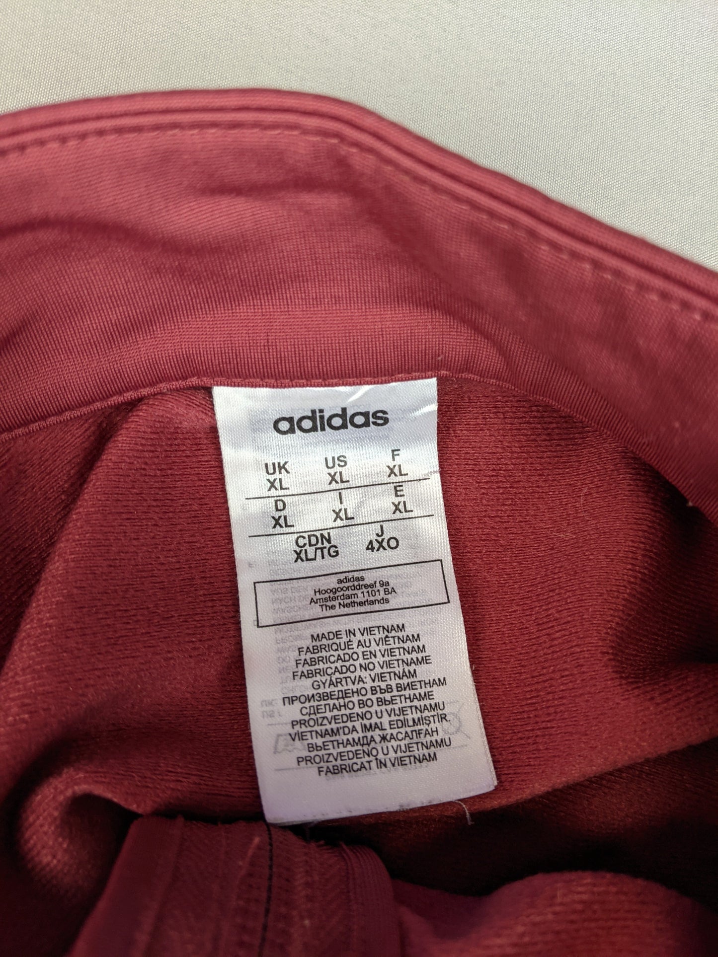 Size label of maroon Adidas track jacket