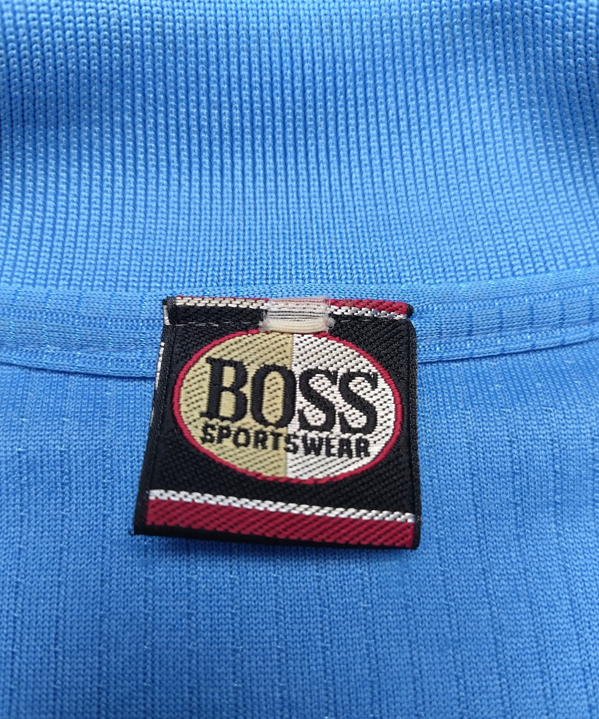Close-up of the tag on the blue BOSS polo shirt