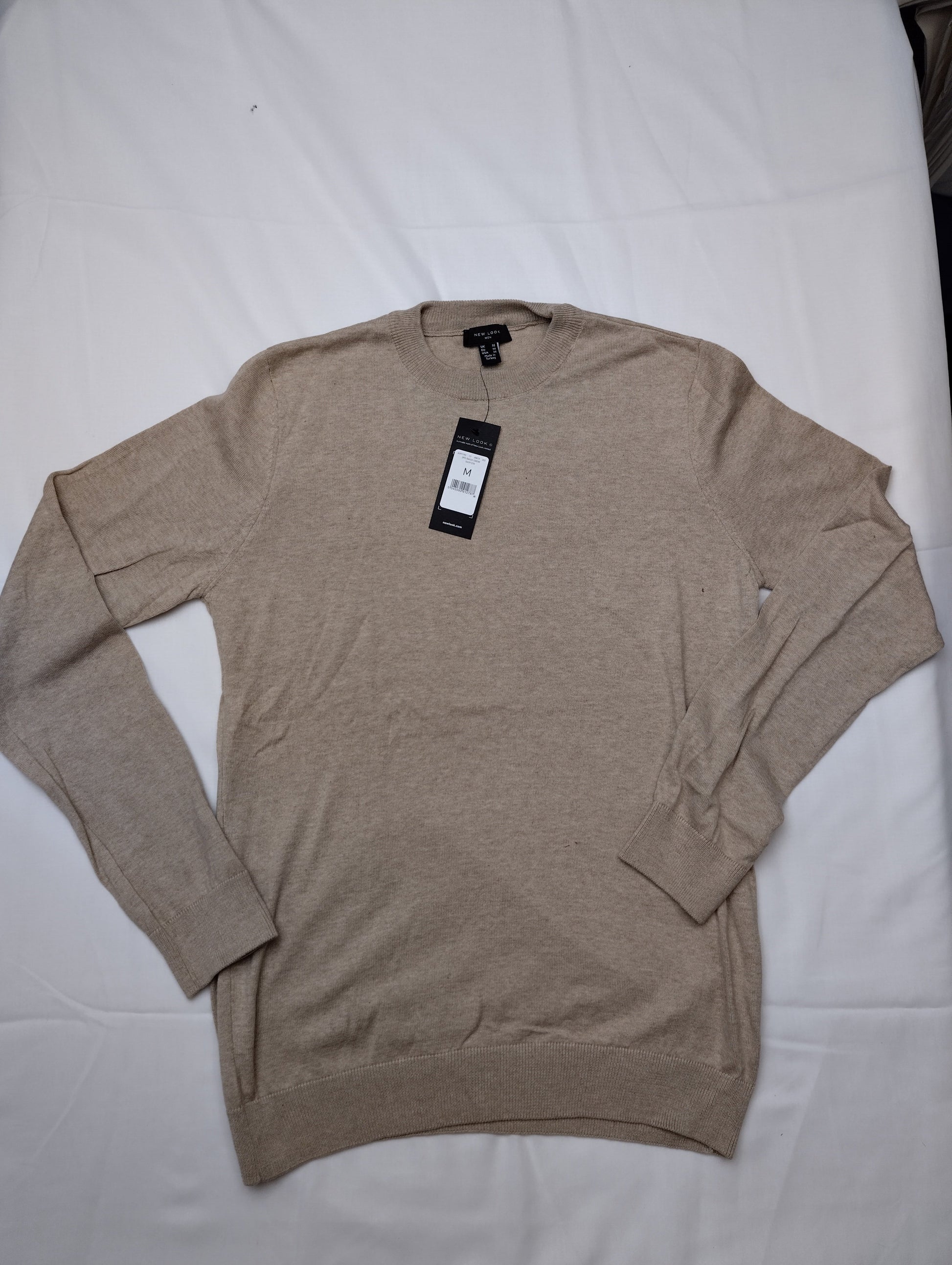 Sweater laid out flat with tags