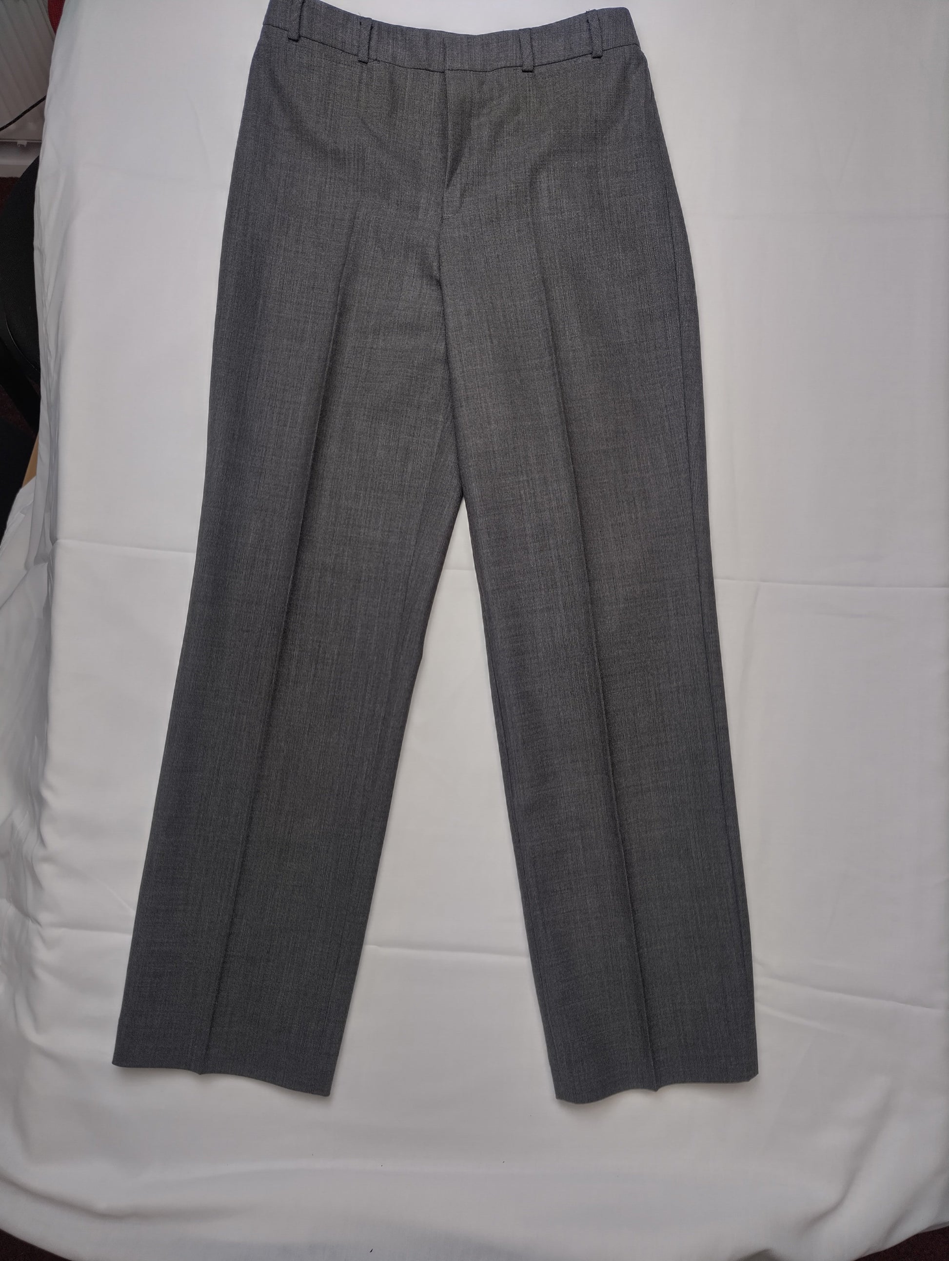 Full view of grey dress pants on a white background