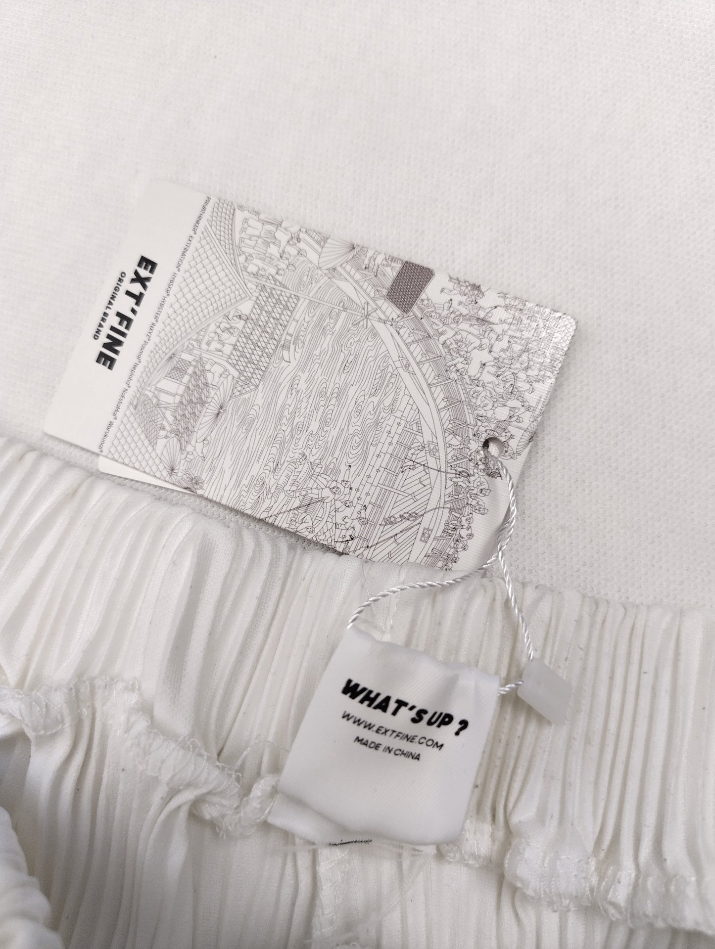 Tag detail on the waistband of the white pants