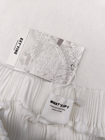 Tag detail on the waistband of the white pants