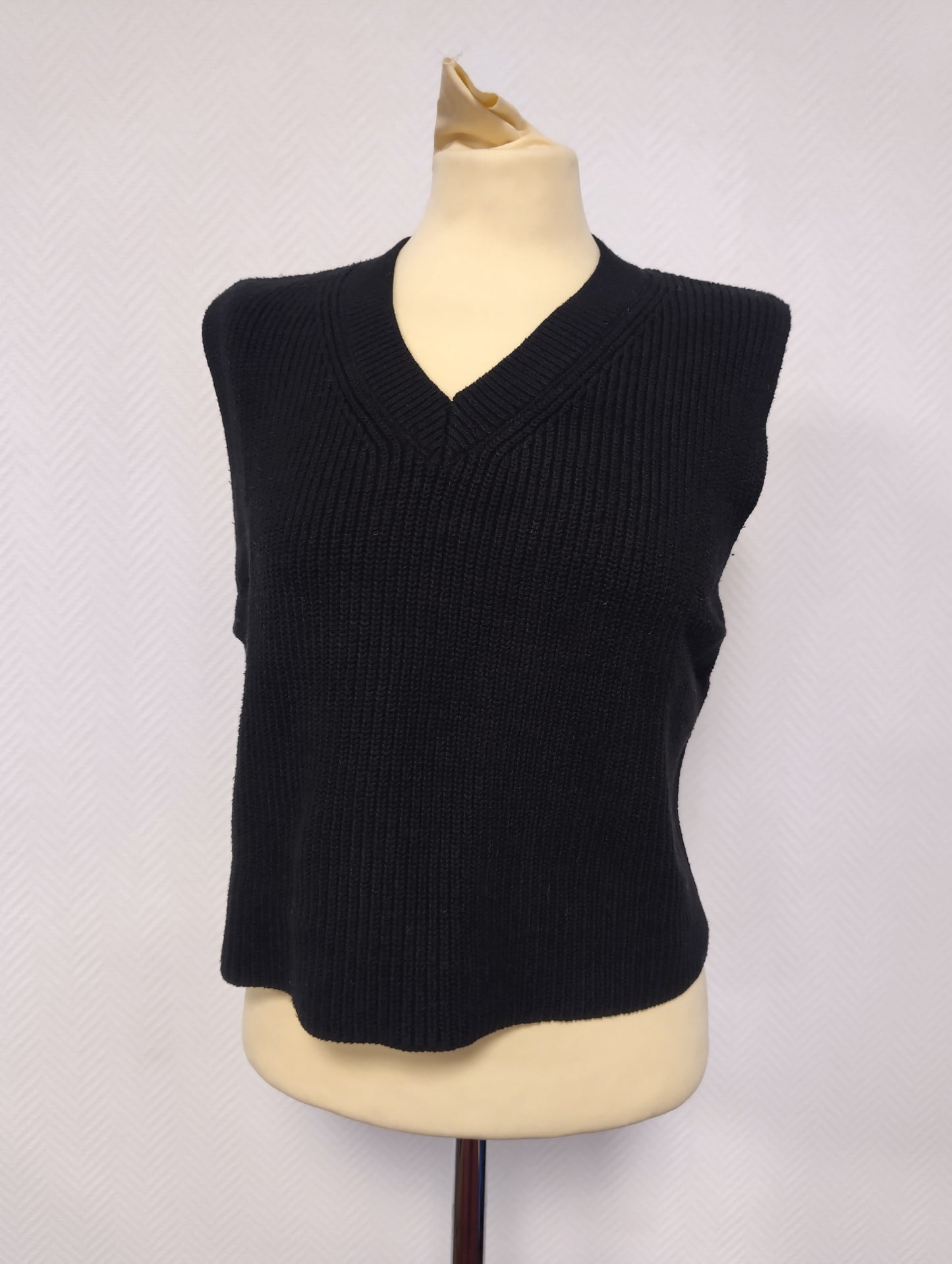 Front view of the black sleeveless knit top