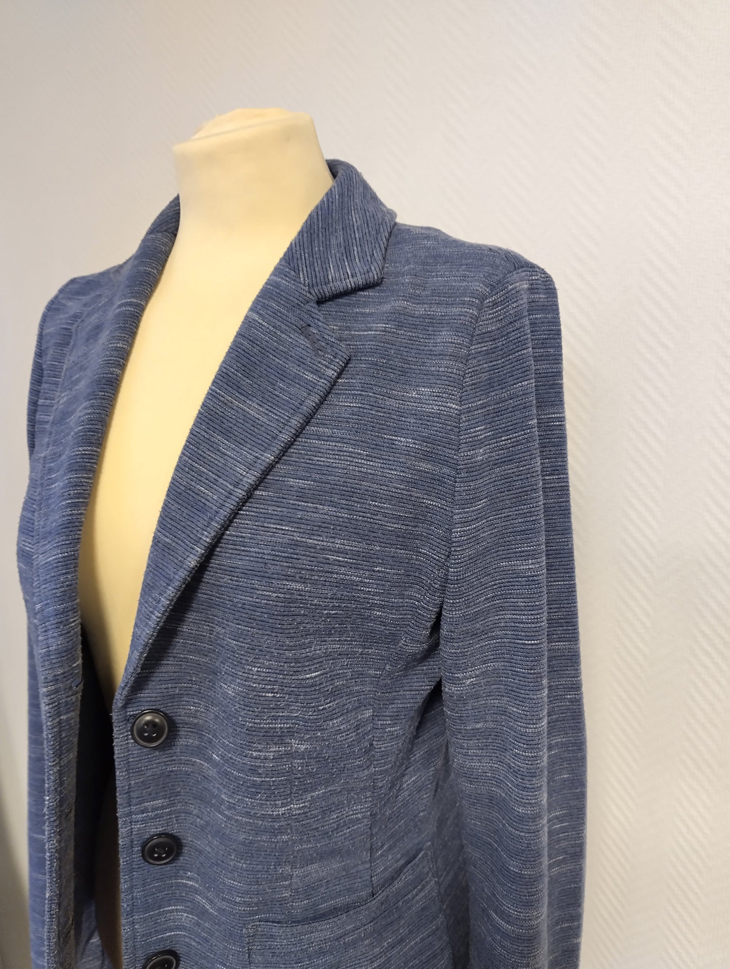 Side view of a blue blazer on mannequin