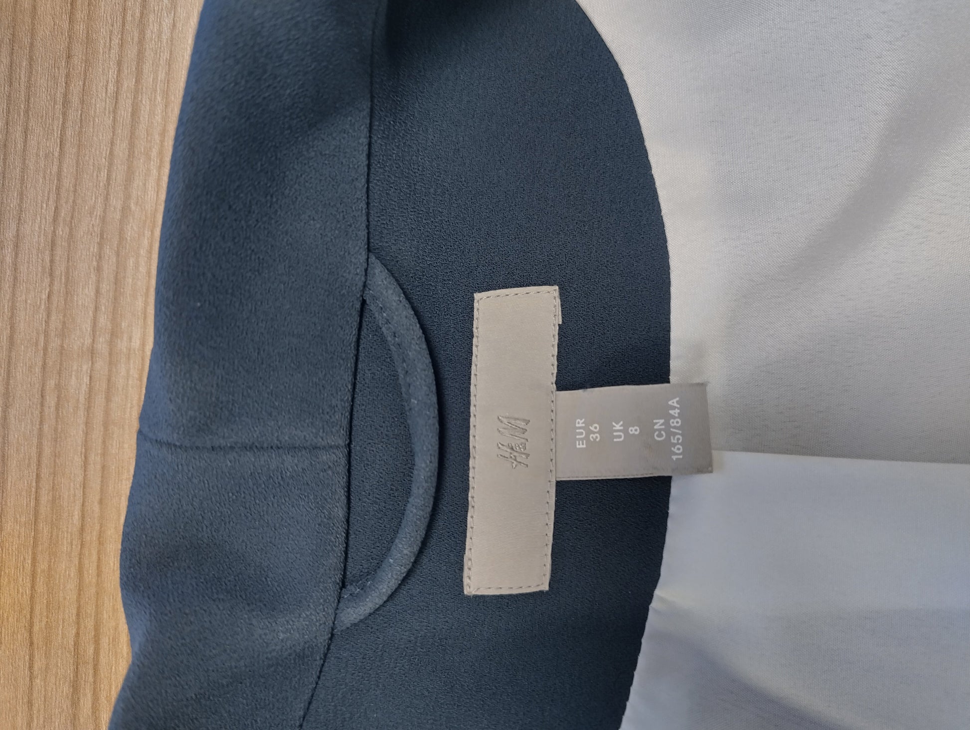 Tag of dark navy blazer showing size and brand
