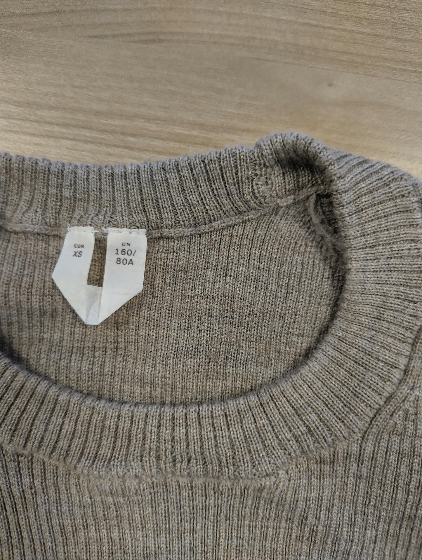 Close-up of the sweater's label showing size XS