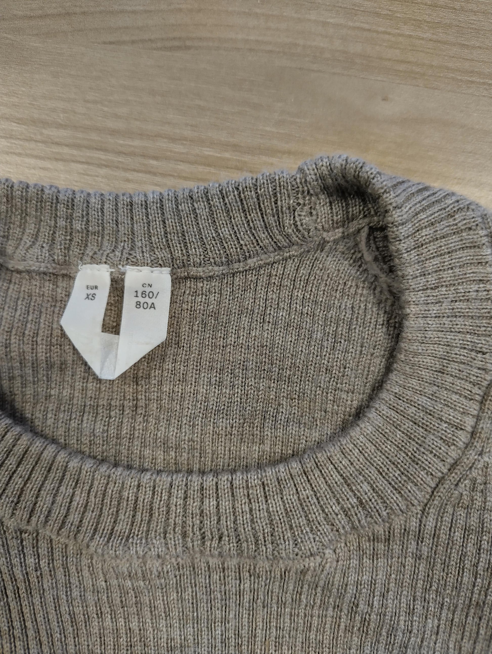 Close-up of the sweater's label showing size XS