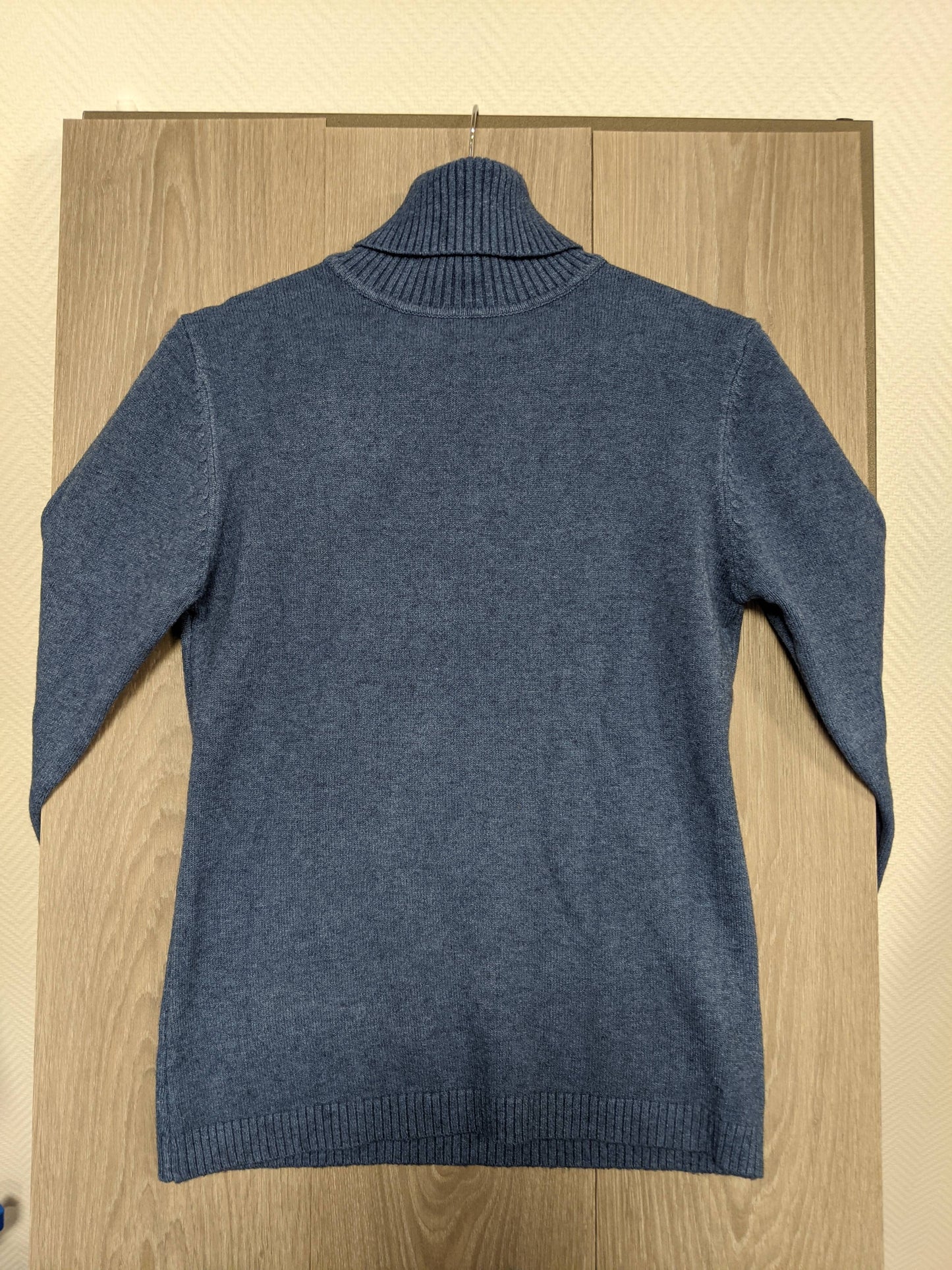 Back view of a blue turtleneck sweater