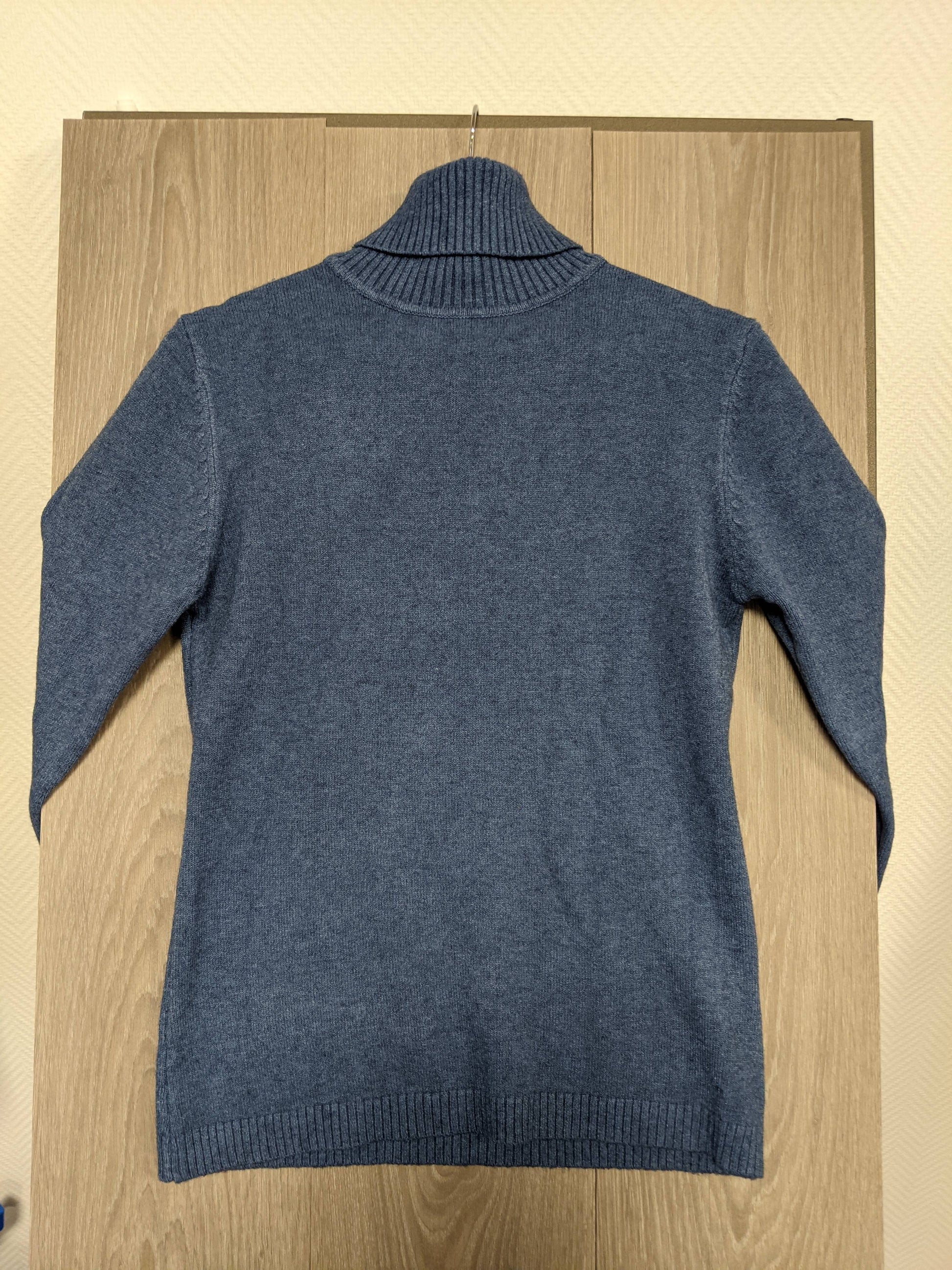 Back view of a blue turtleneck sweater
