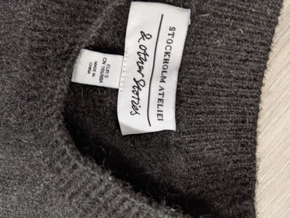 Tag inside the black striped sweater noting brand and size