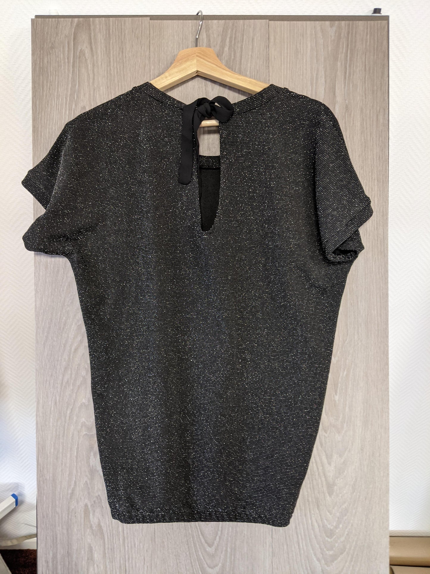 Back view of the sparkly black top showing the tie feature