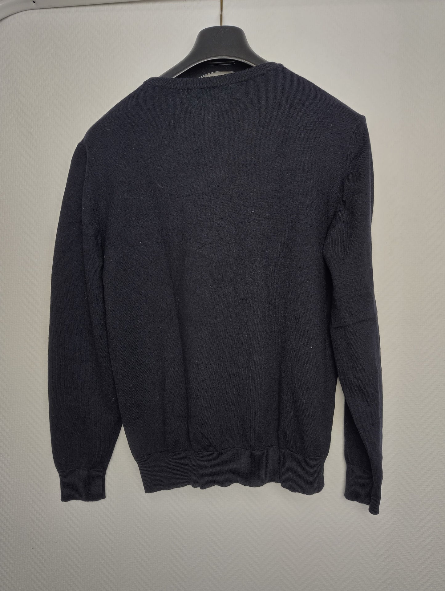 Back view of black sweater on hanger