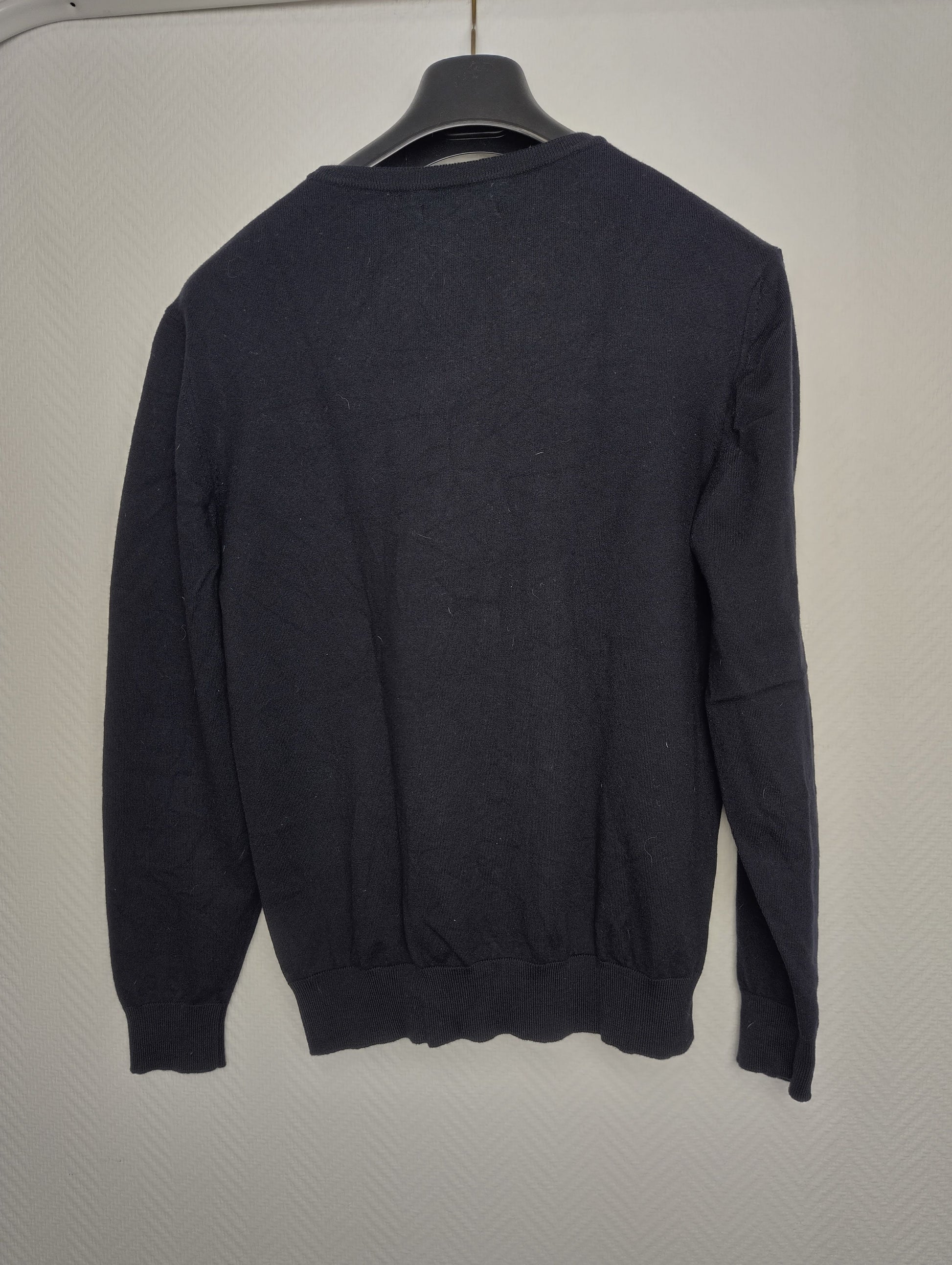 Back view of black sweater on hanger