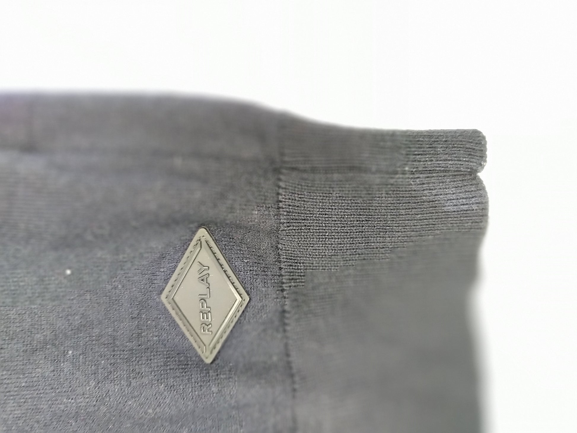 Close-up of sweater sleeve with logo
