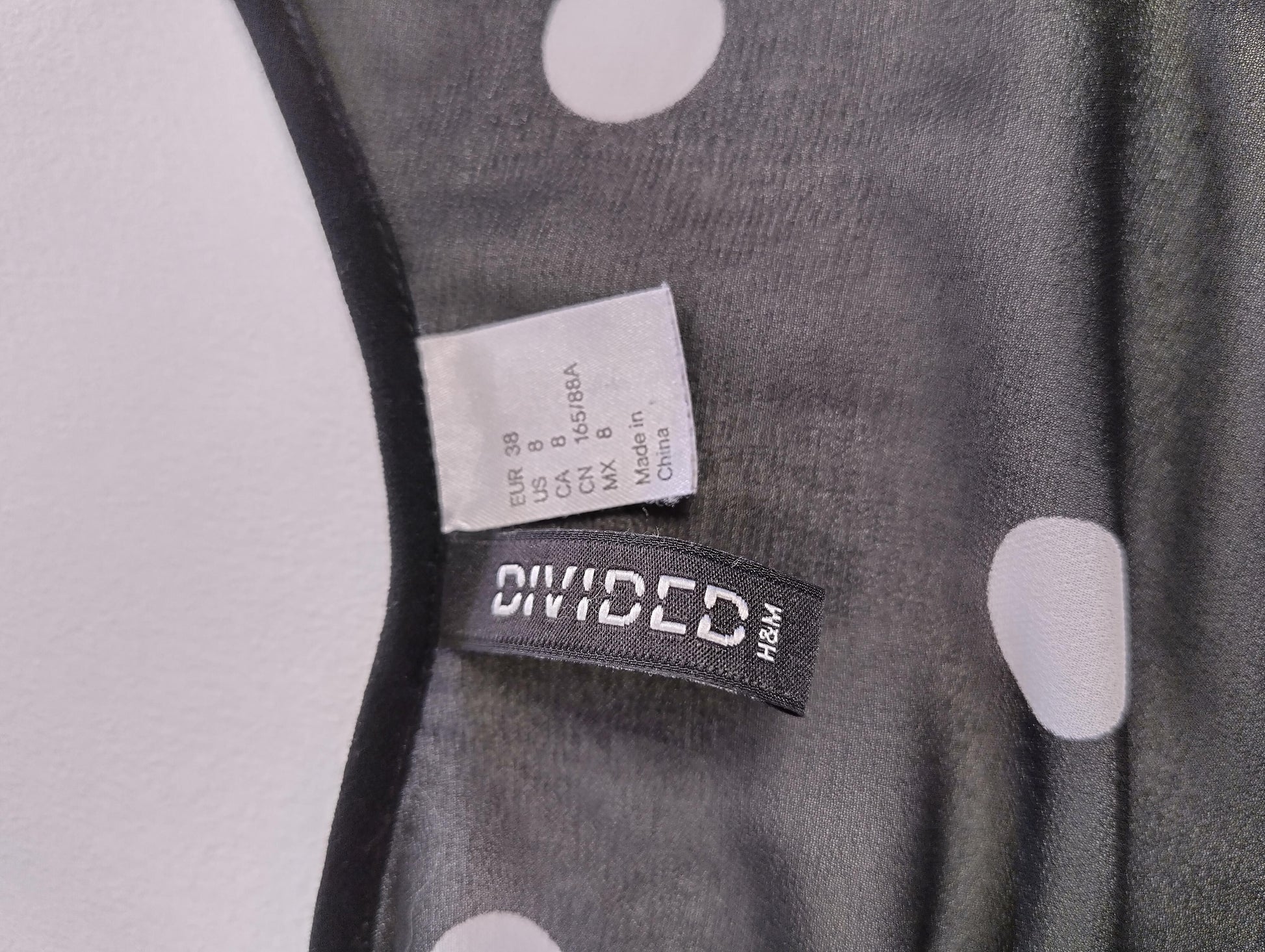 Size label of black polka dot blouse