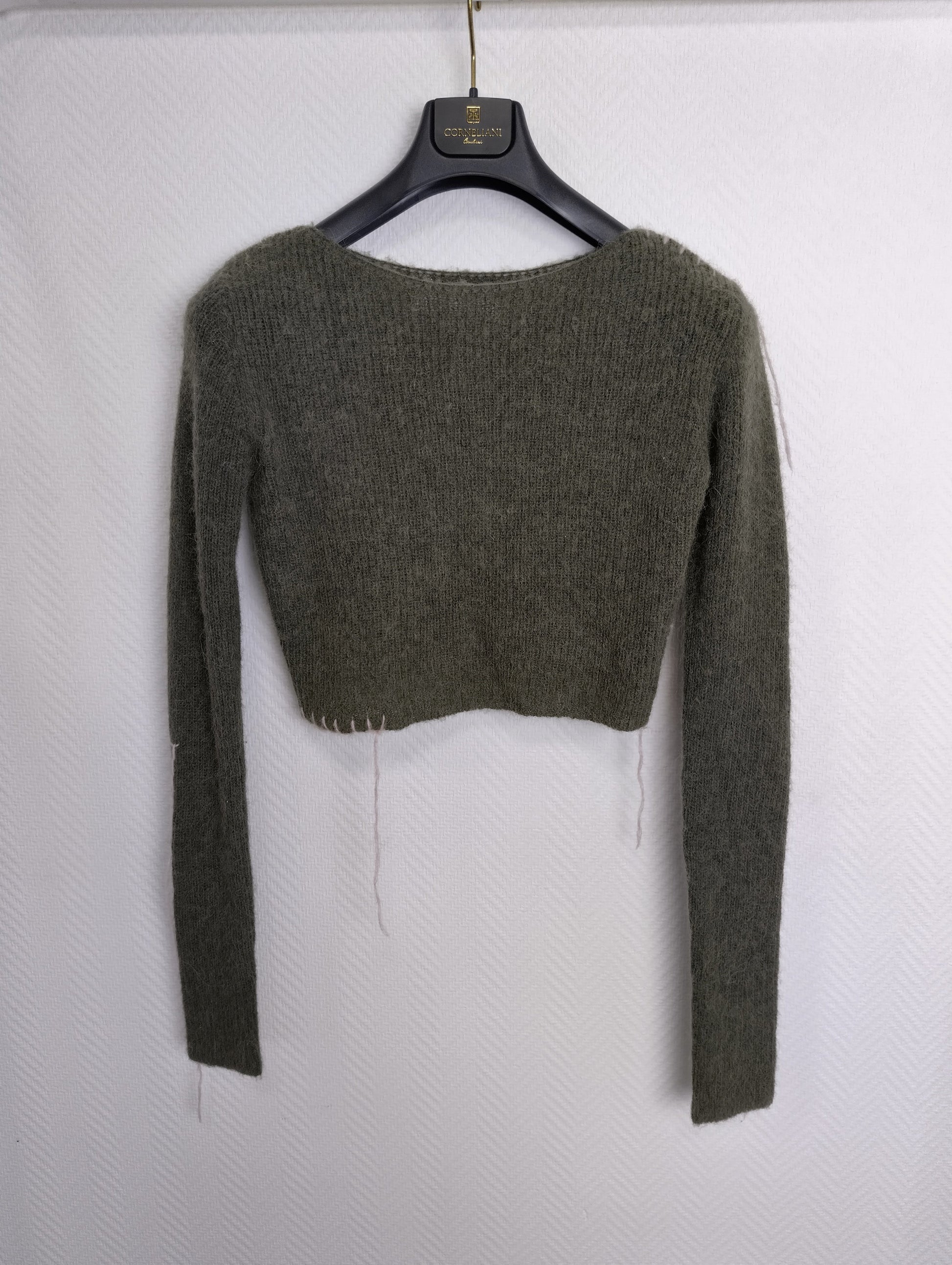 Back view of cropped sweater with hanger