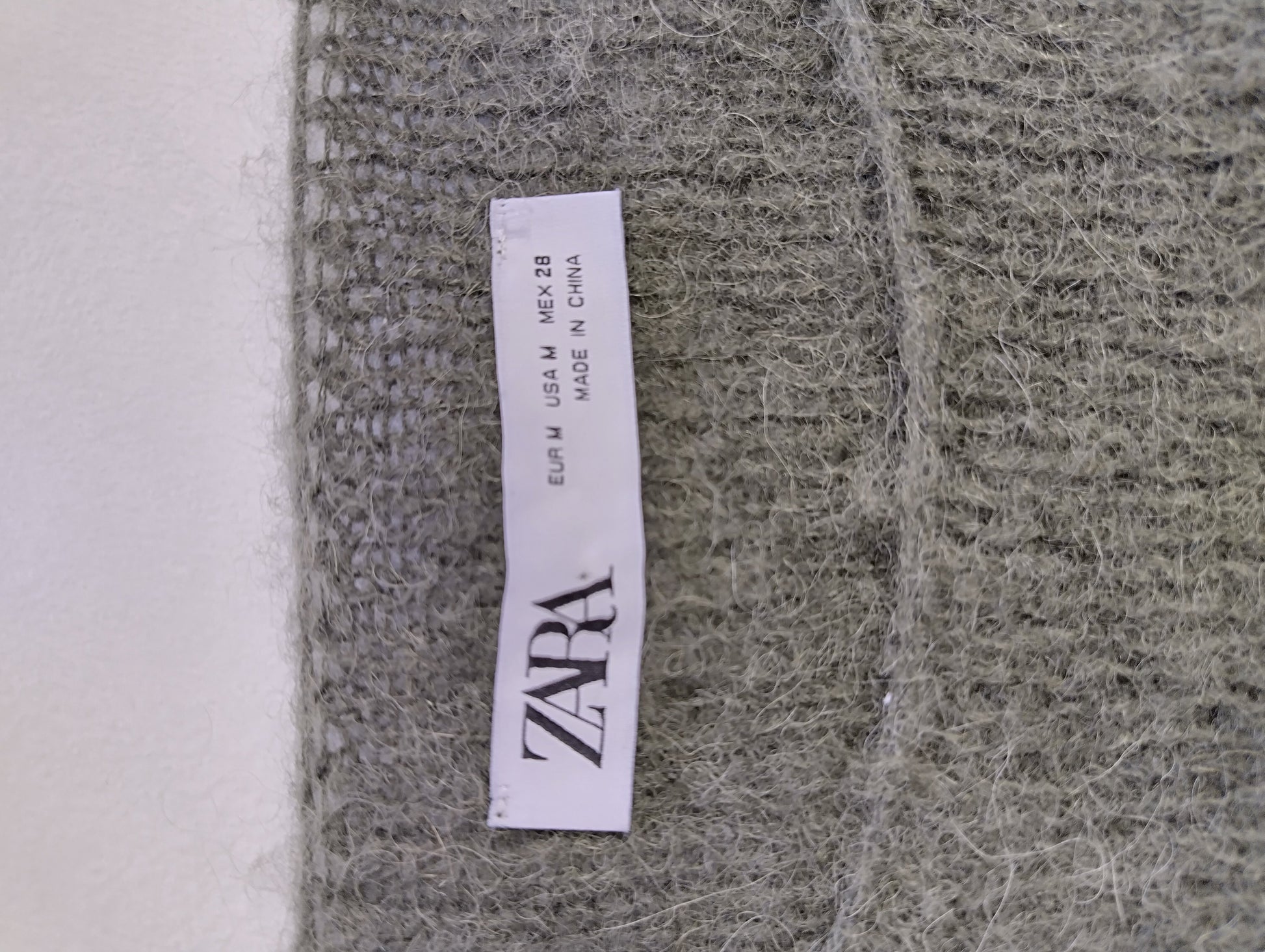 Zara label on olive green sweater