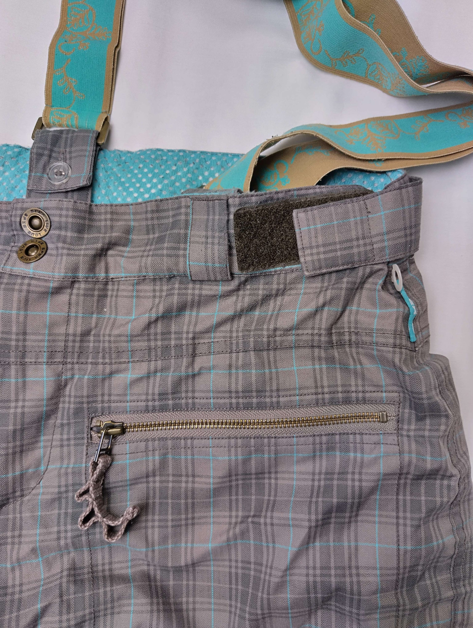 Close-up of the pants details - zip pocket and strap
