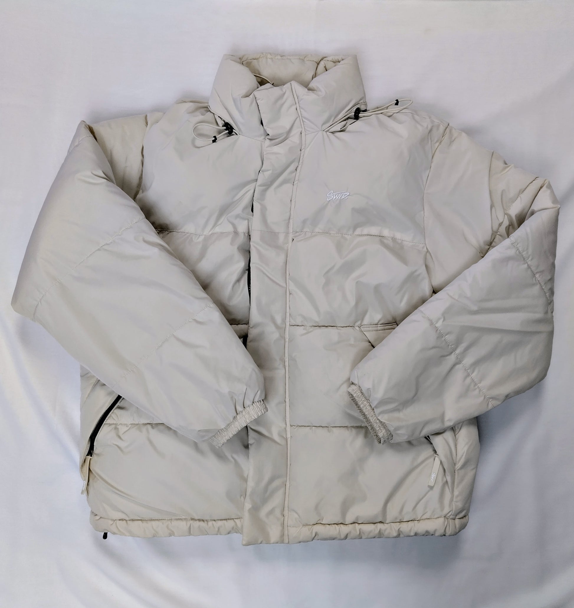 Front view of cream puffer jacket laid flat